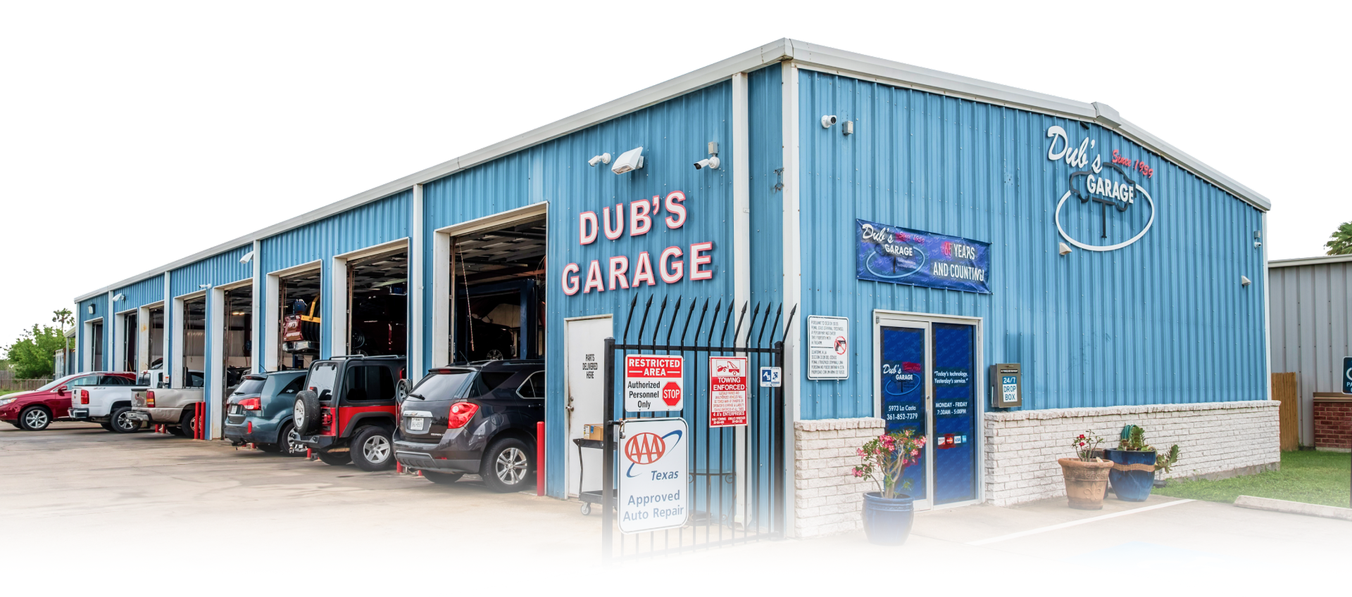 Blue metal storefront with glass doors and windows on a sunny street corner | Dub's Garage