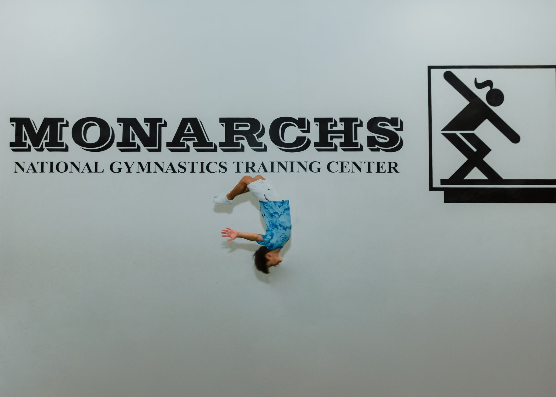 Gymnast mid-air, flipping in front of 