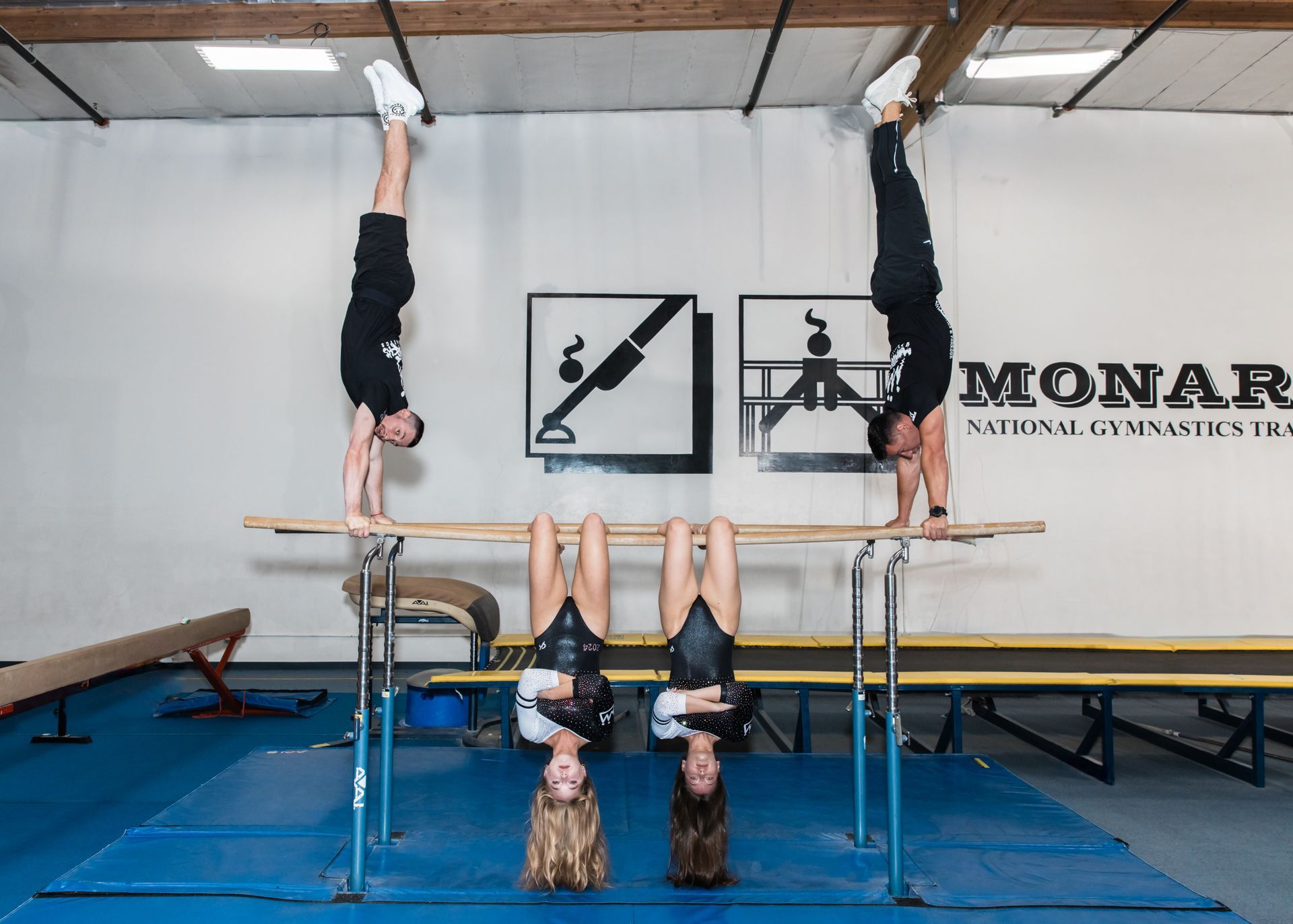Two gymnasts in handstand on bars.