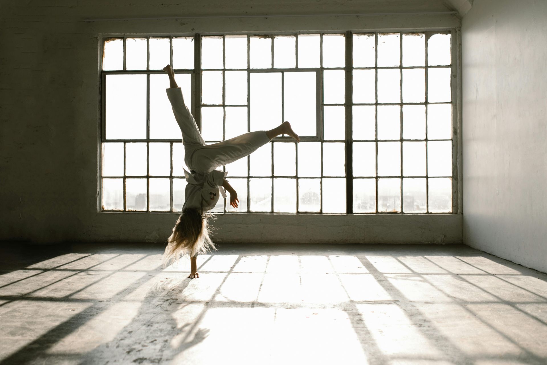 Girl in green shorts stretches on a purple mat, reaching to the side.