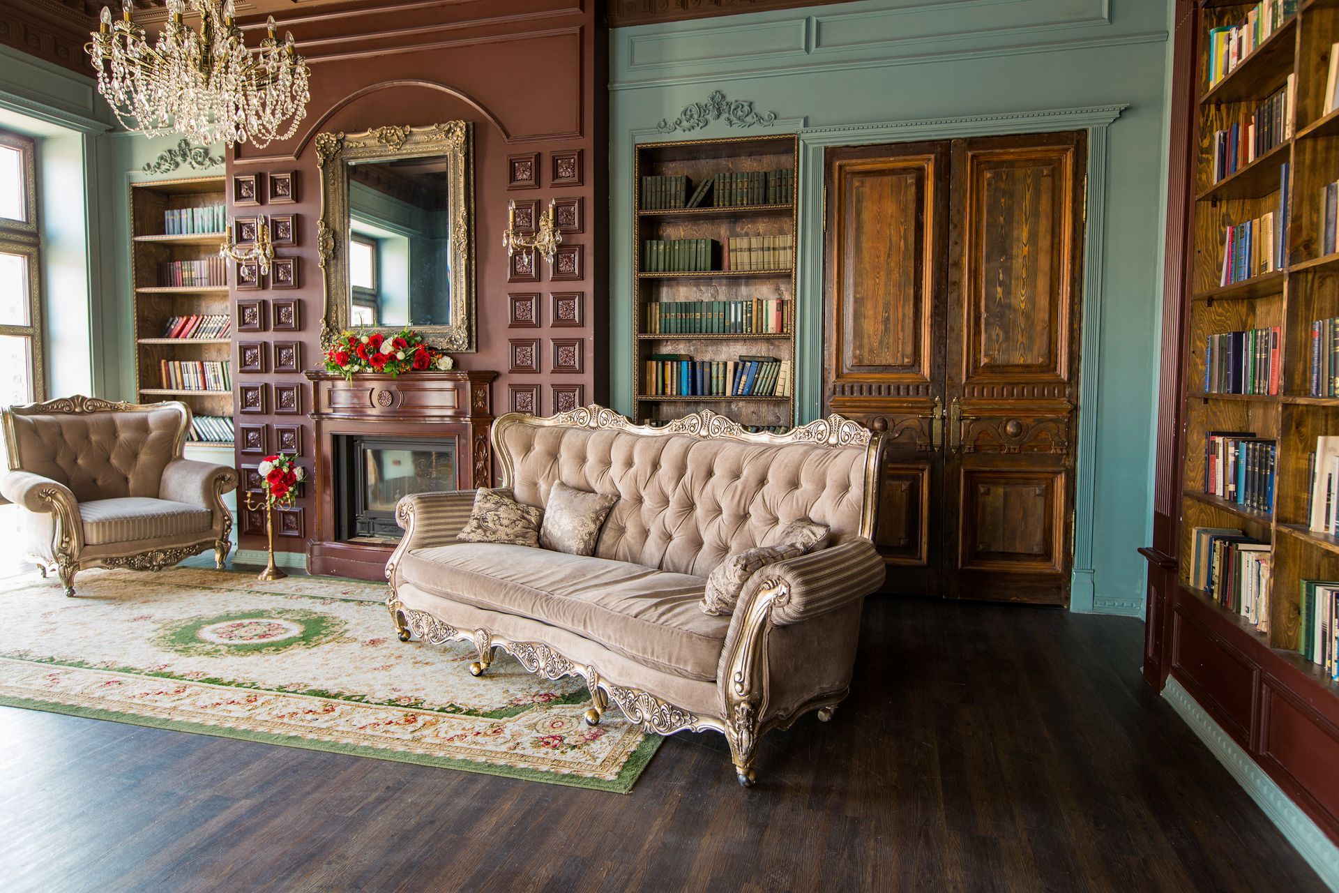 A living room with a couch , chair , bookshelf and fireplace.