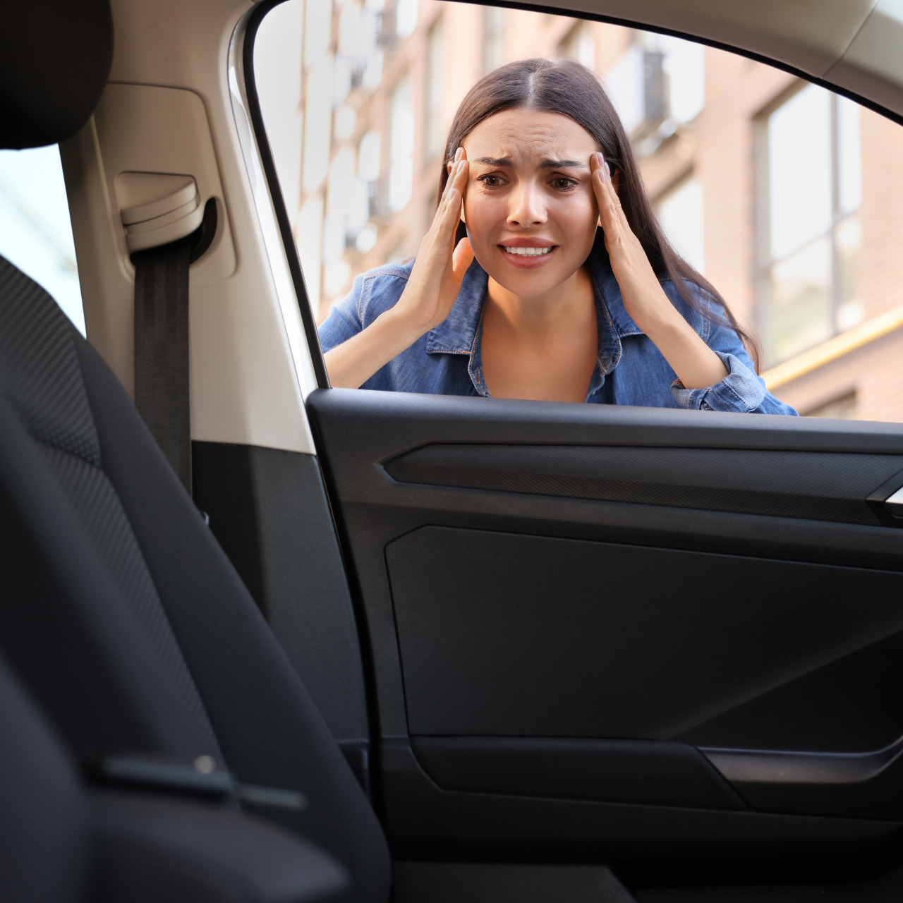 A woman is sitting in the driver 's seat of a car