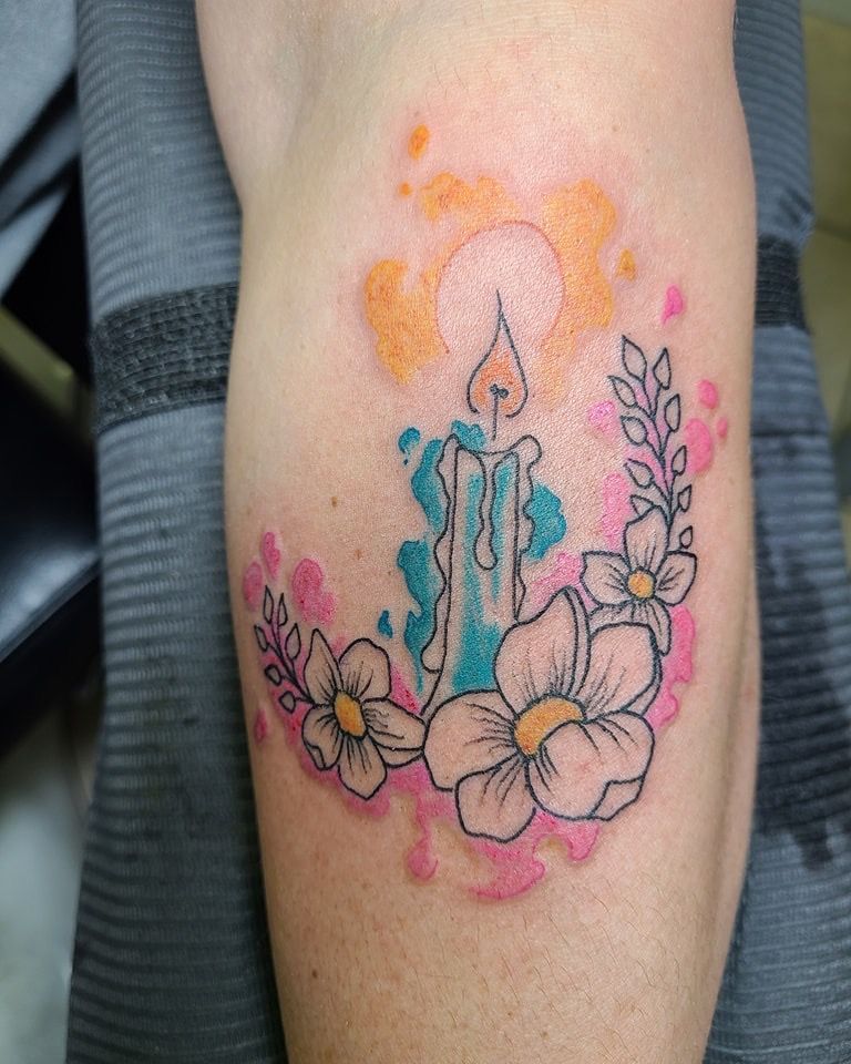 A tattoo of a candle and flowers on a person 's arm