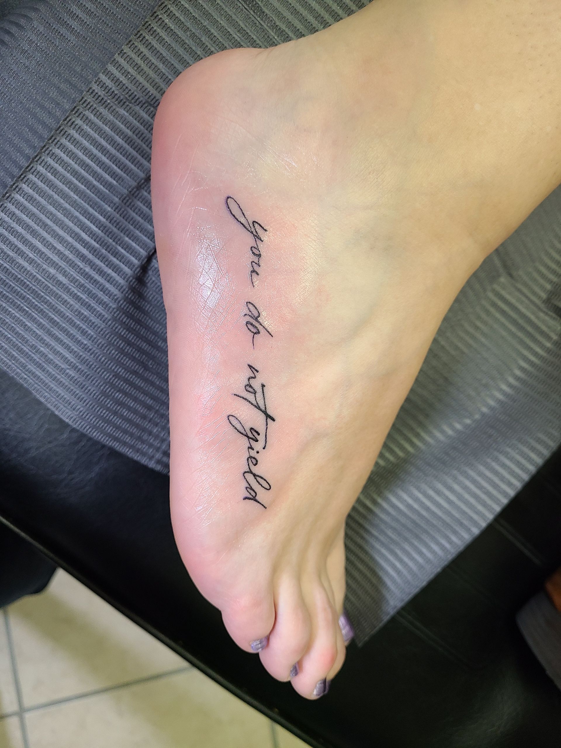 A woman has a tattoo on her foot that says you 're the way god