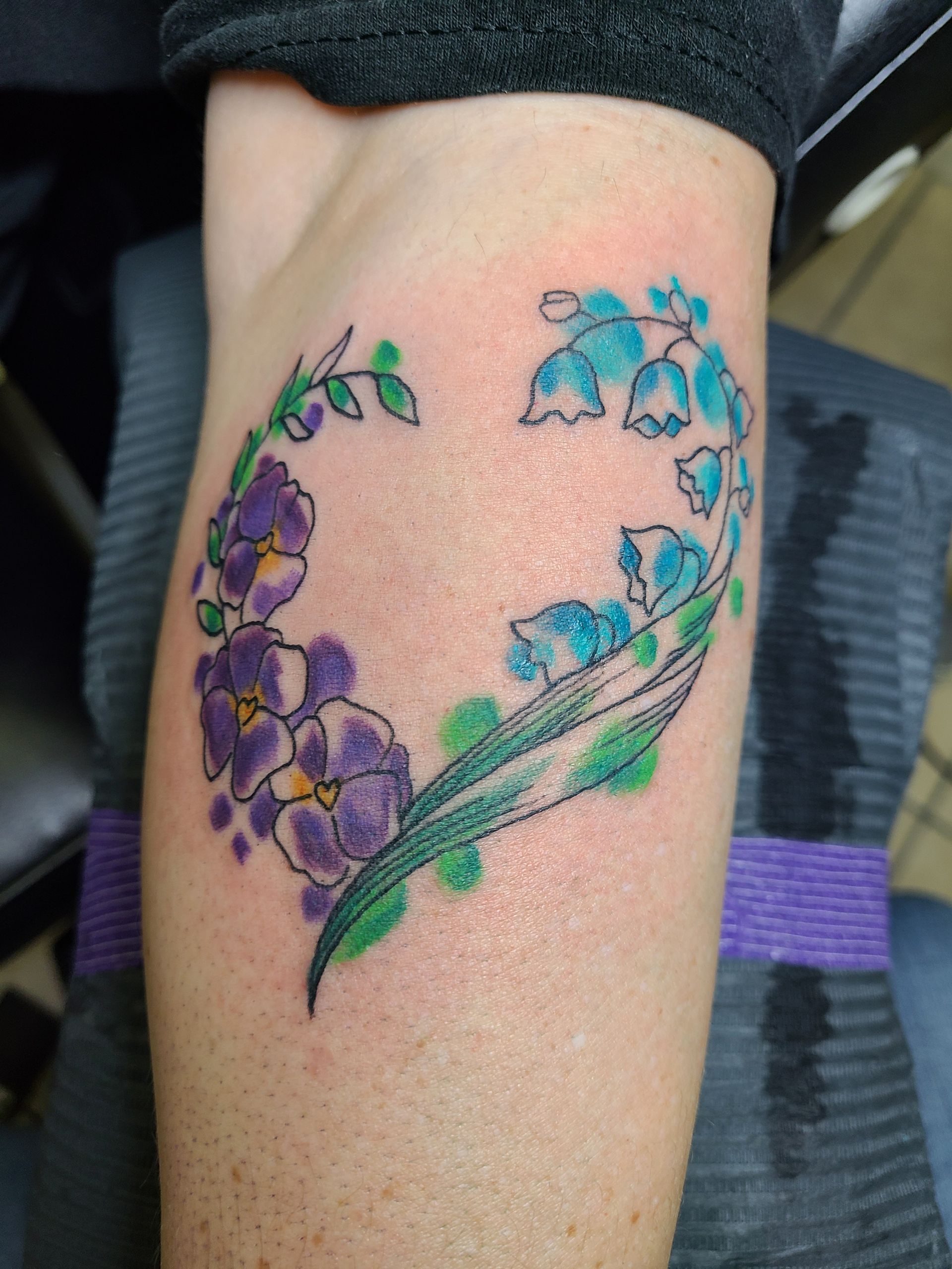 A person has a heart shaped tattoo on their leg