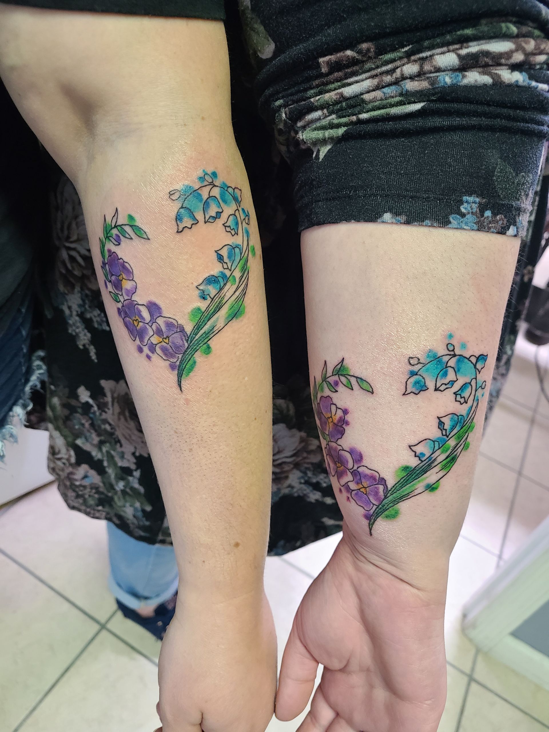 A woman has a heart shaped tattoo on her wrist.