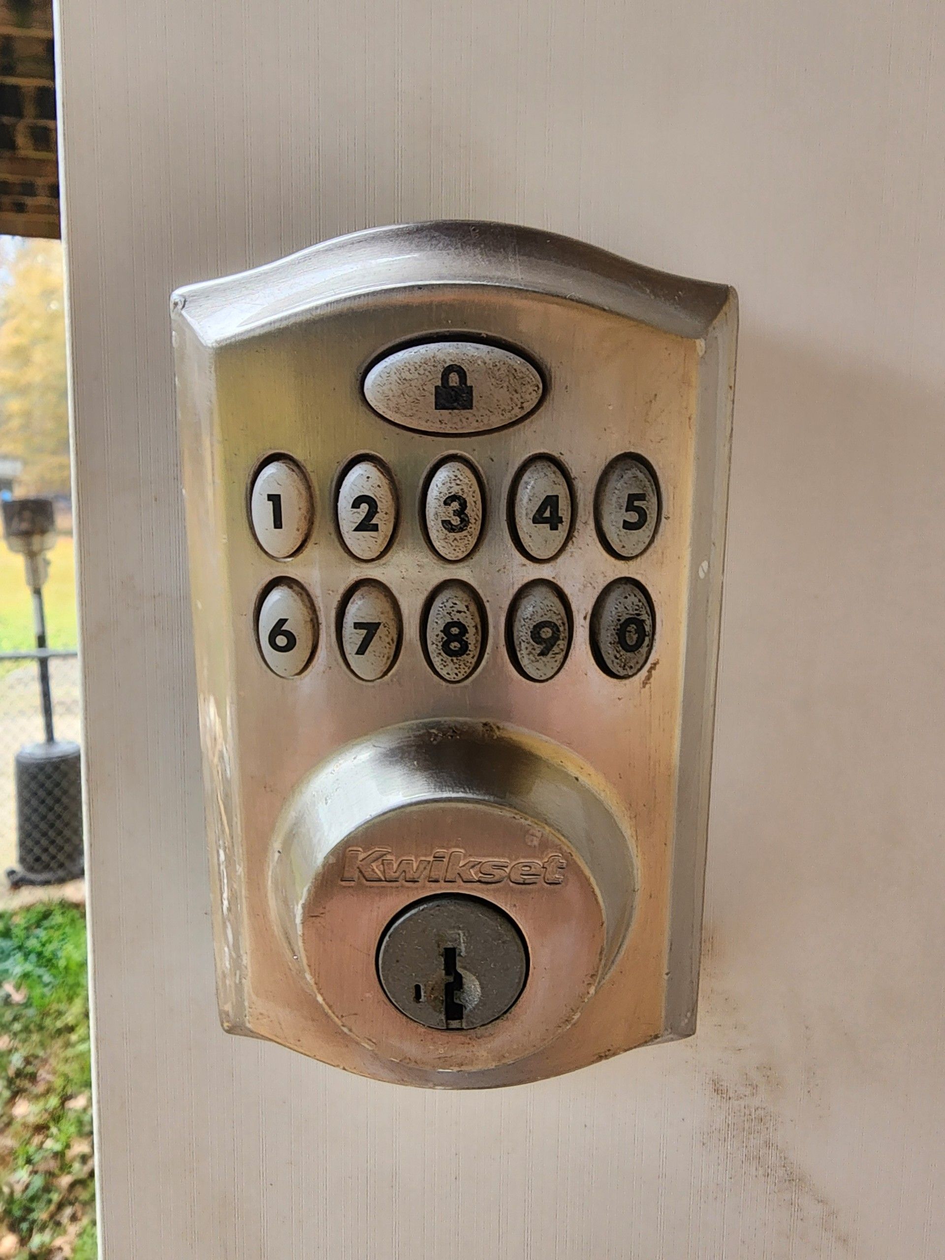 Silver keypad door lock with numbered buttons and a keyhole.