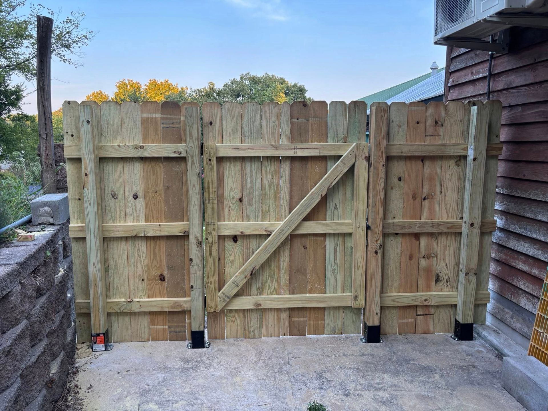Wooden fence with a gate in a yard.
