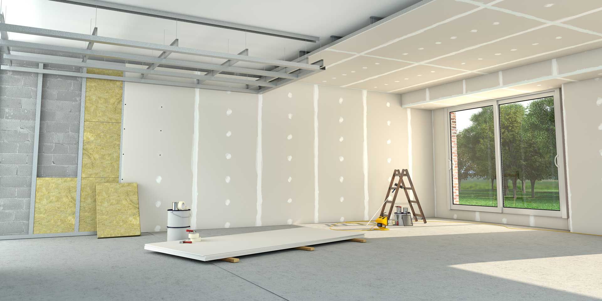 Person using a putty knife to apply white drywall compound to a tan wall.