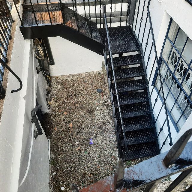 A black staircase leading up to the second floor of a building