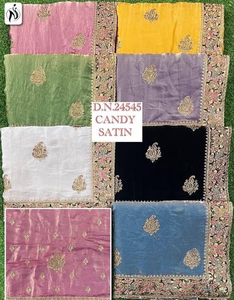 Assorted satin sarees in various colors with embroidered detailing, displayed on grass.