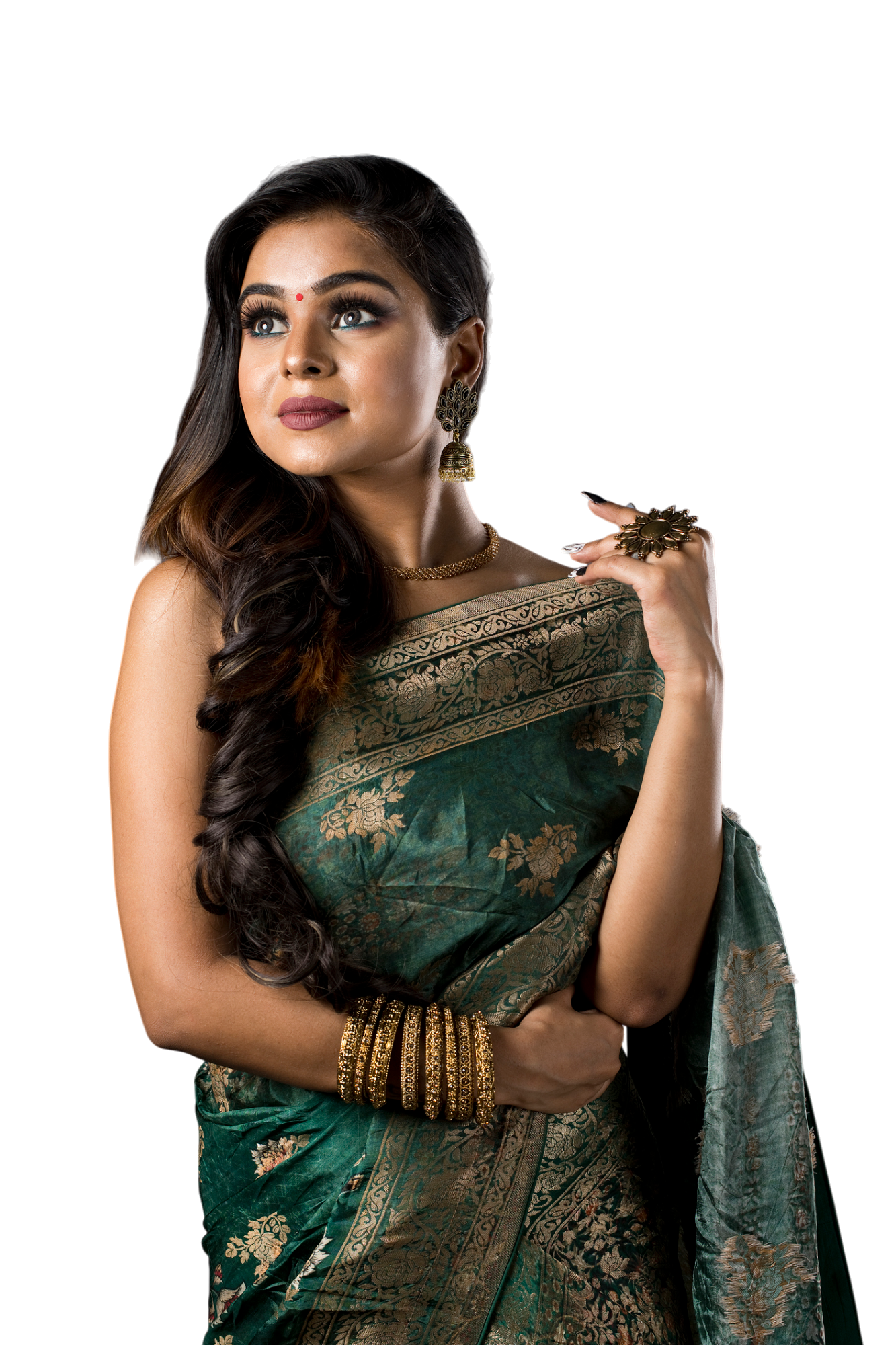 Woman in green and gold sari, looking up, with jewelry.