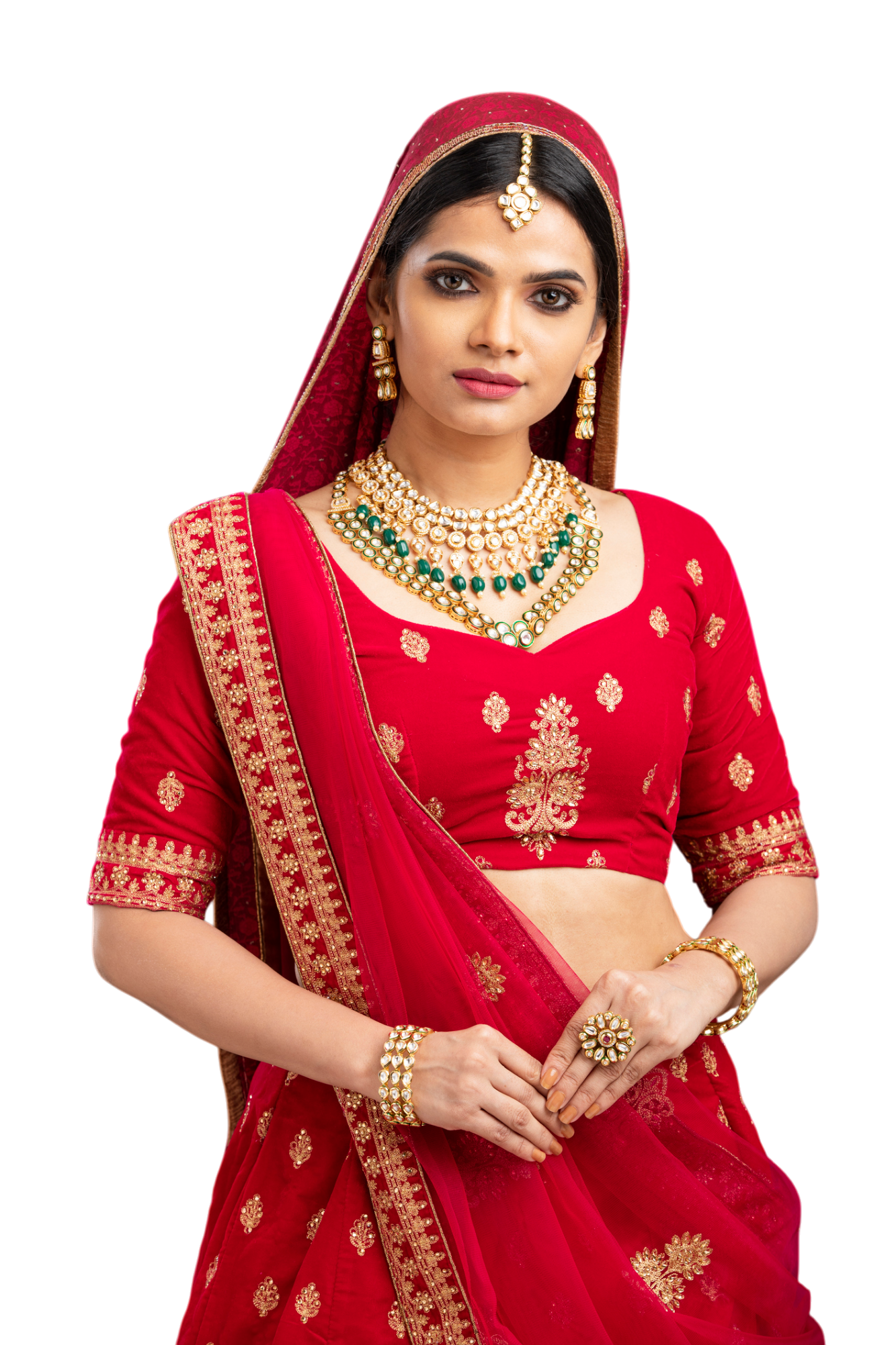 Woman in a red bridal outfit, wearing gold jewelry, looking at the camera.