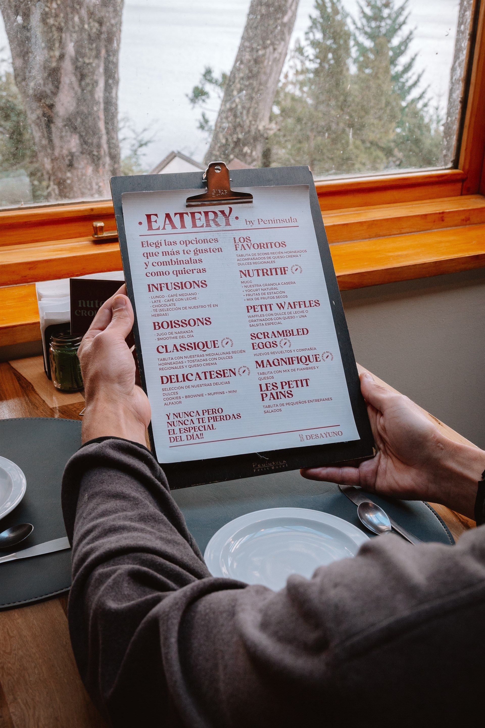 Una persona sostiene un portapapeles con un menú en él.