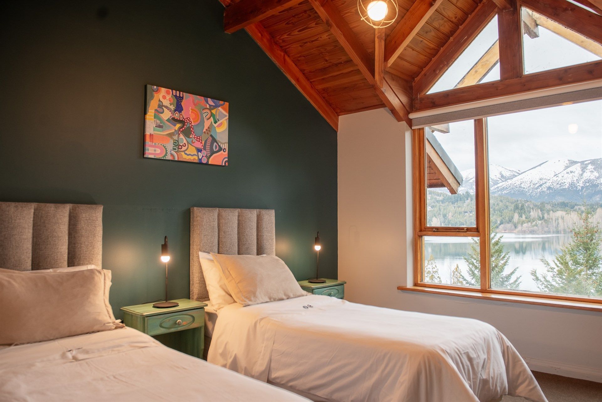 Un dormitorio con dos camas, una ventana y un cuadro en la pared.