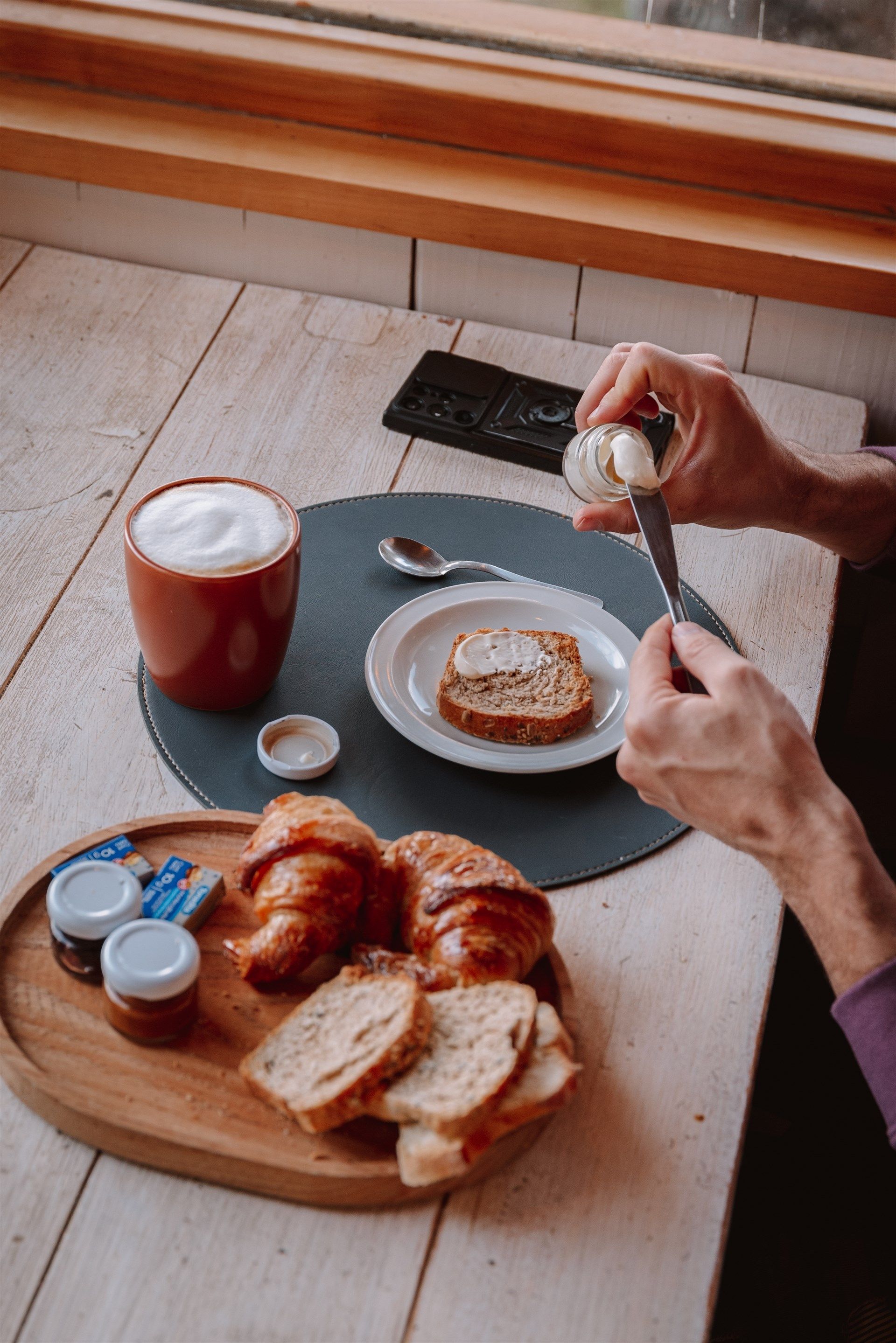 Una persona está untando mantequilla en un trozo de pan.