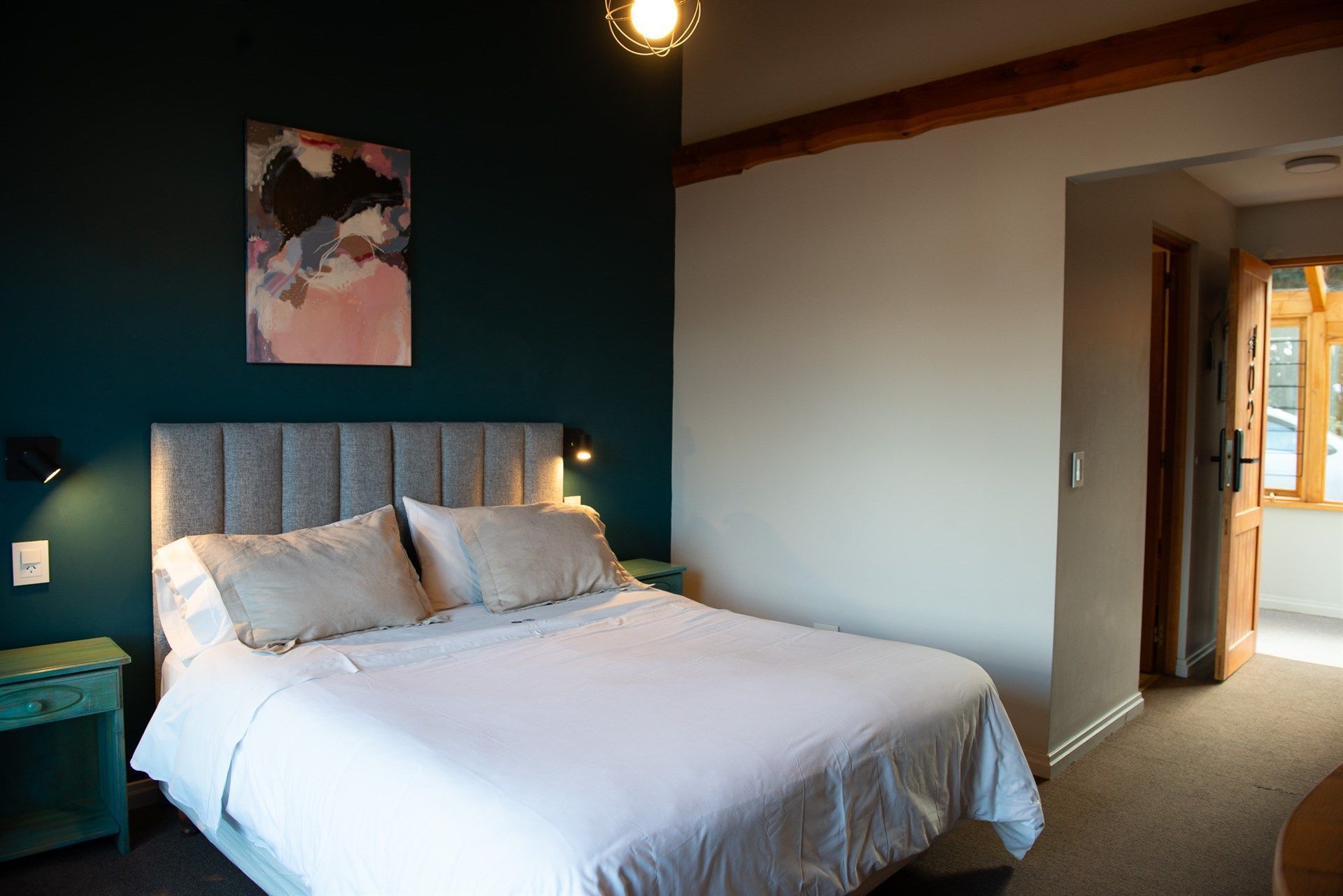 Un dormitorio con una cama king size y un cuadro en la pared.