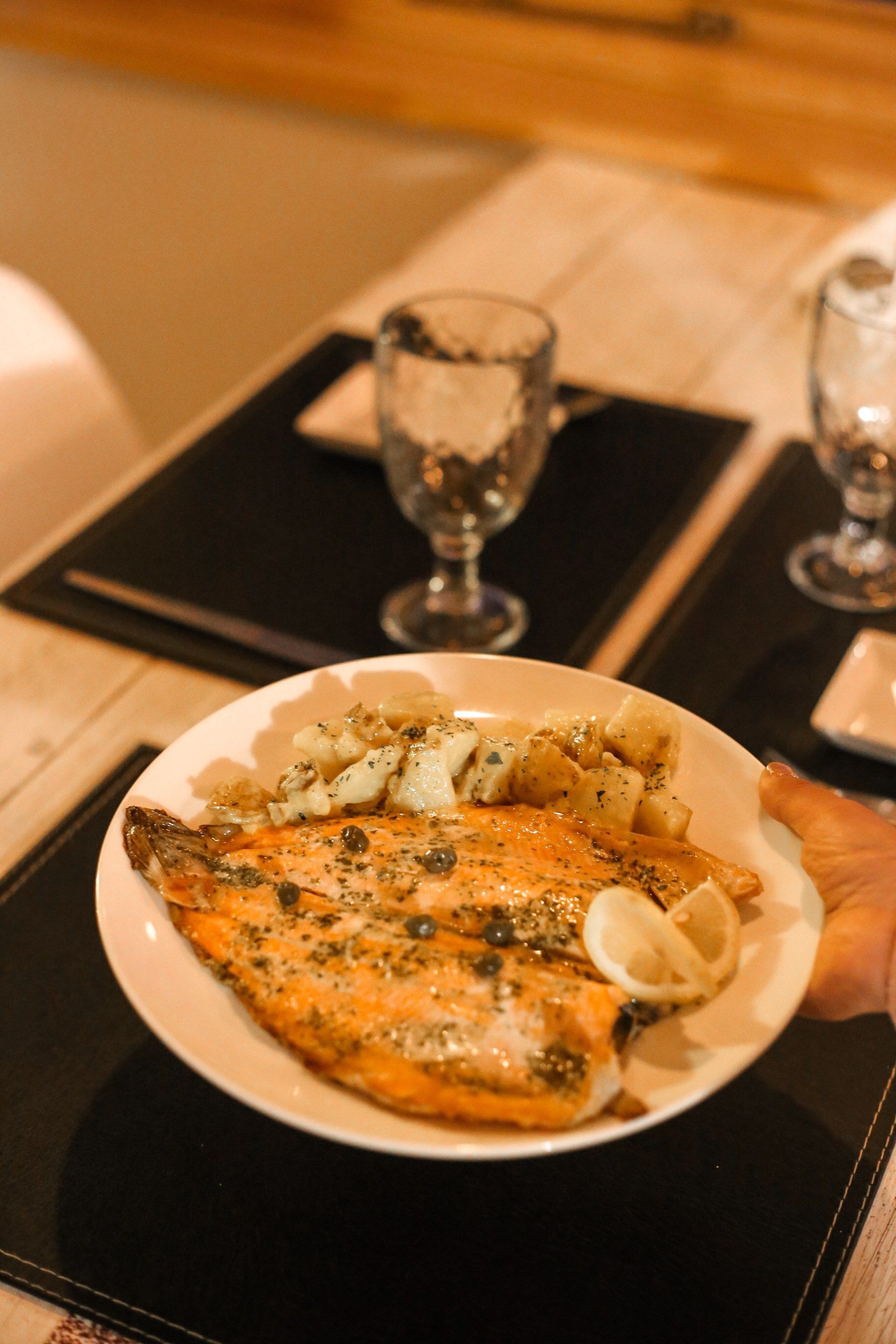 Una persona sostiene un plato de comida sobre una mesa.