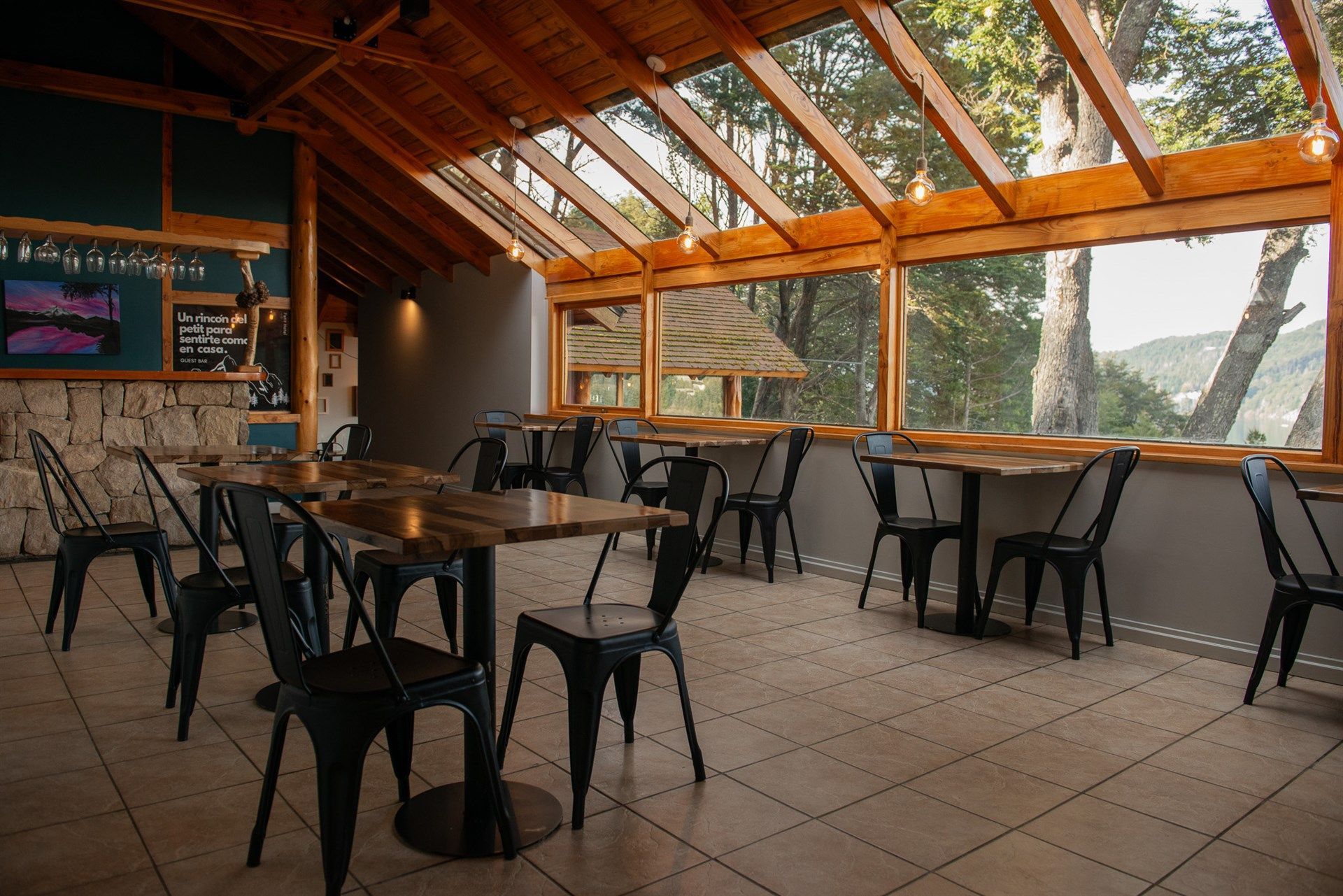 Un restaurante con mesas y sillas bajo un techo de cristal.