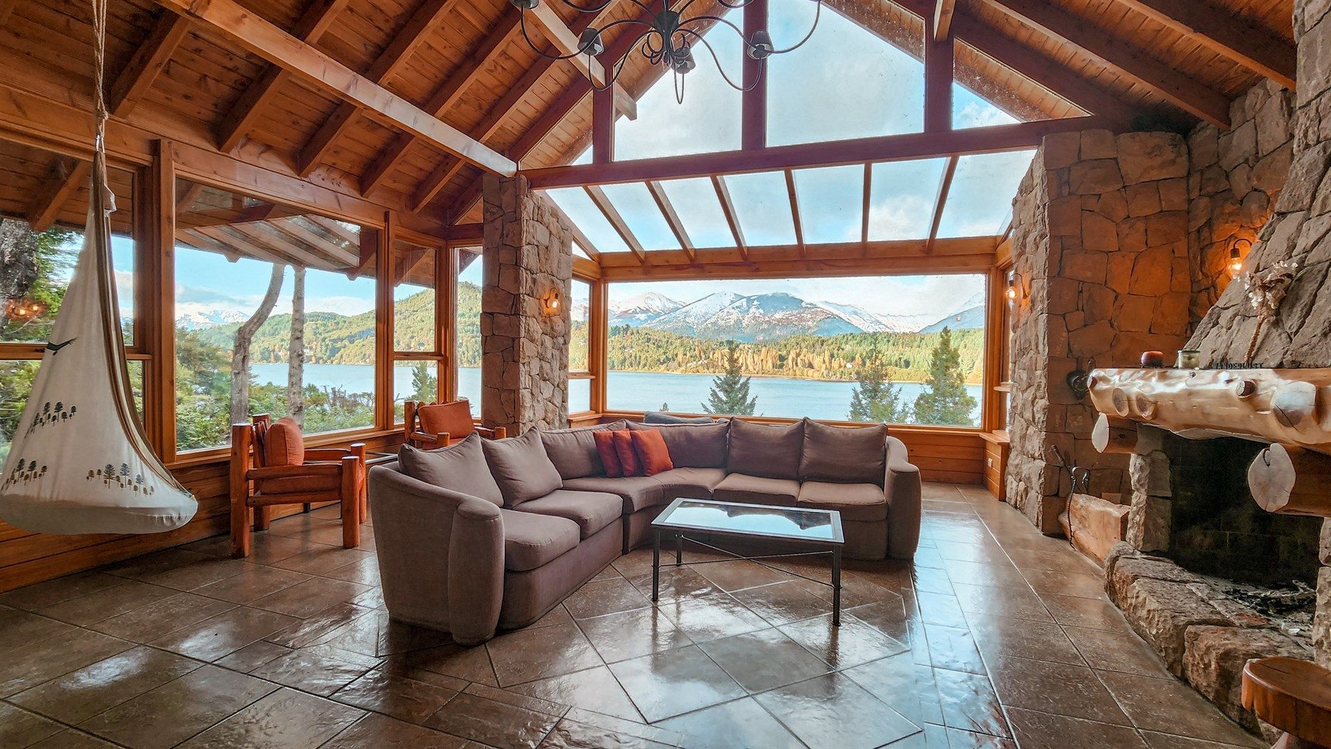 Una sala de estar llena de muebles y una chimenea con vista a un lago.