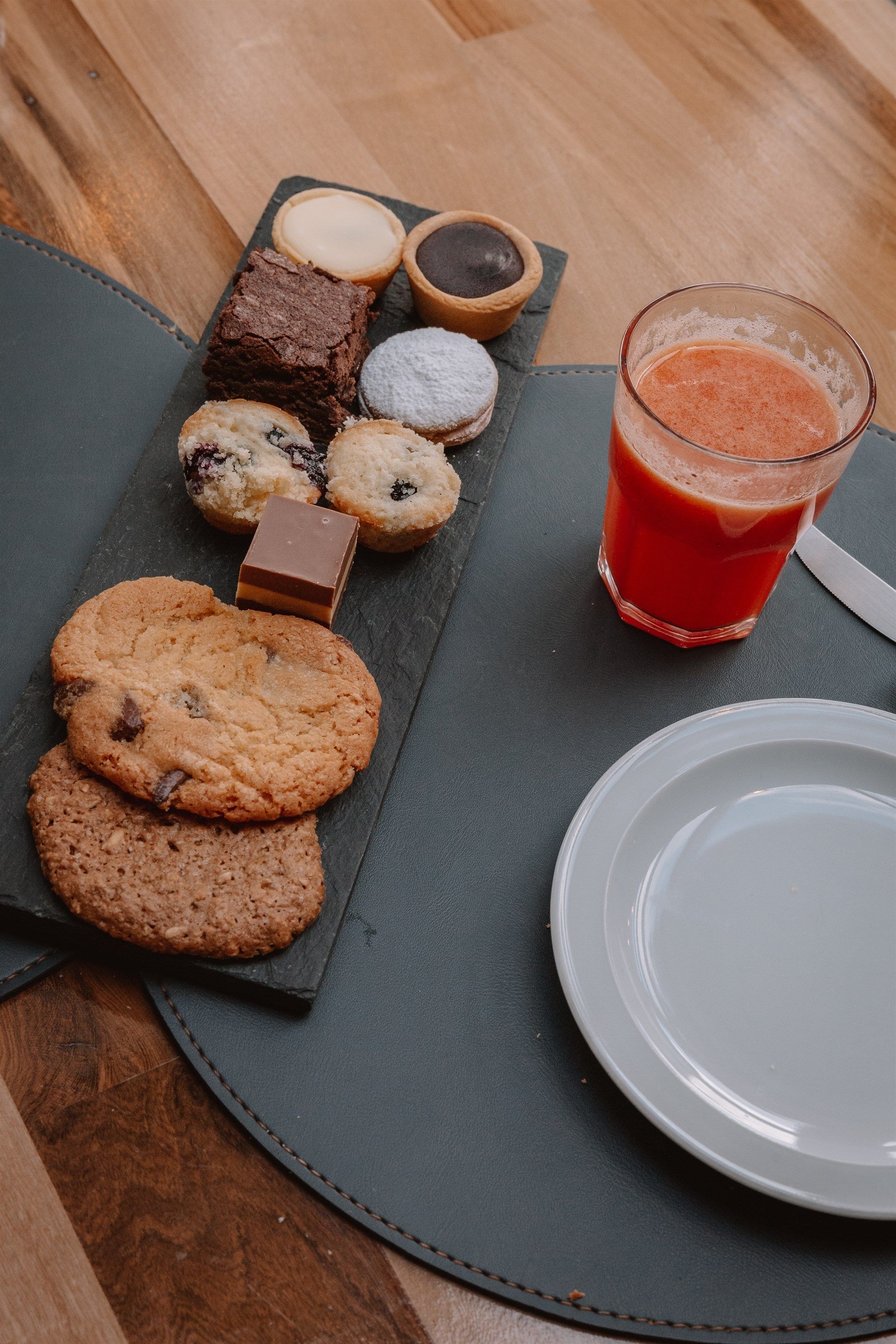 Un plato de galletas y un vaso de jugo en una mesa.