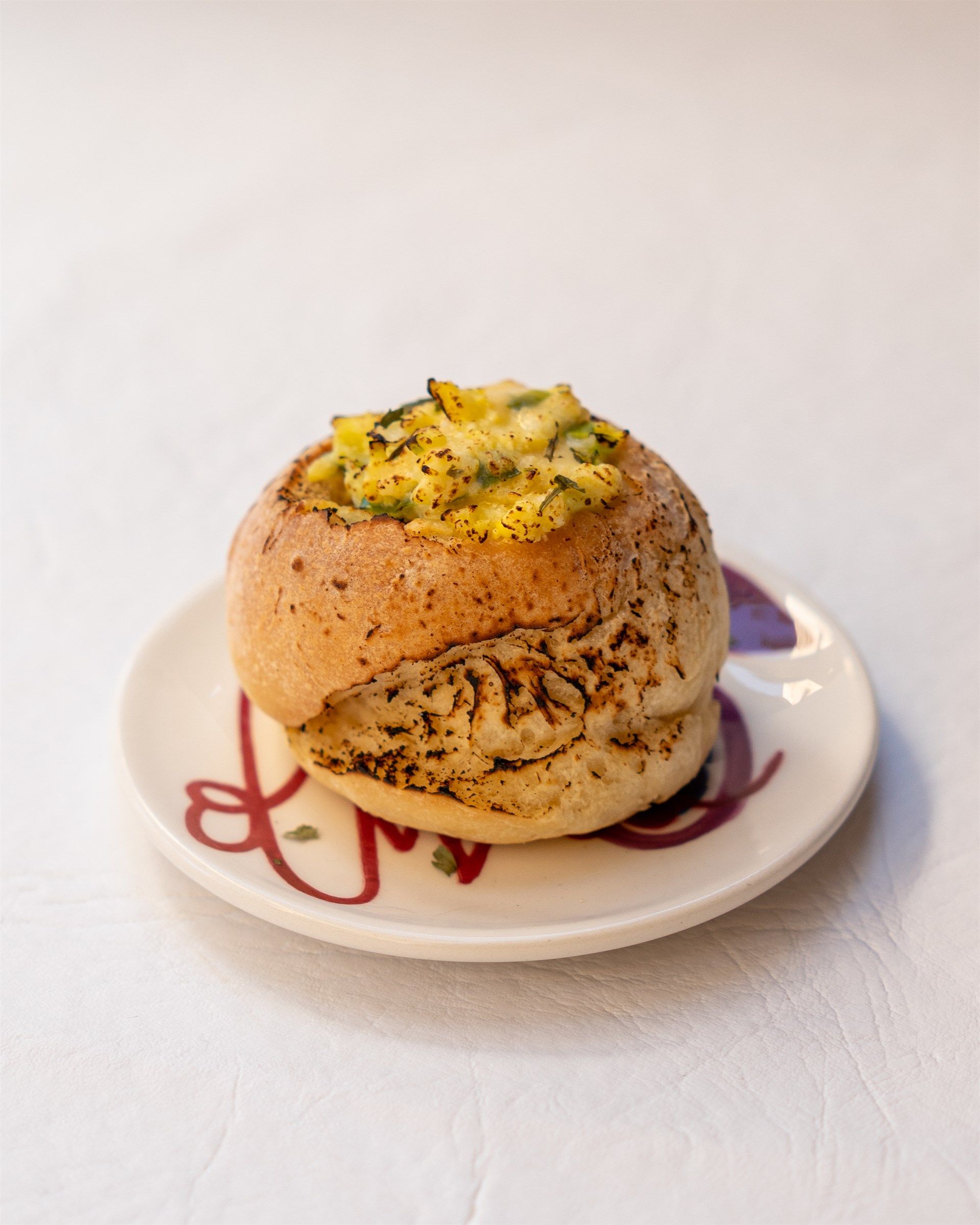 Un primer plano de un sándwich en un plato sobre una mesa.