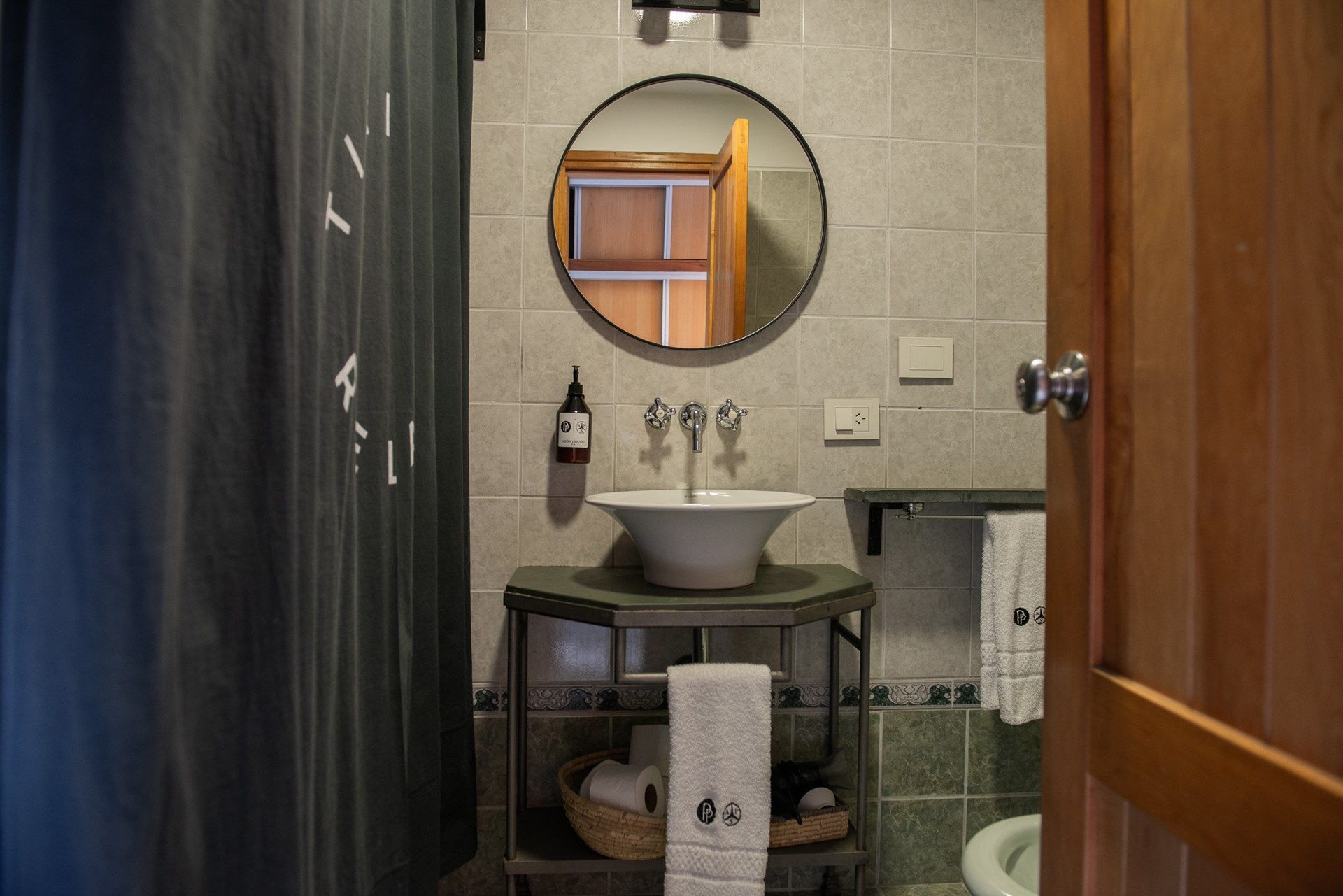Un baño con lavabo, espejo y cortina de ducha.