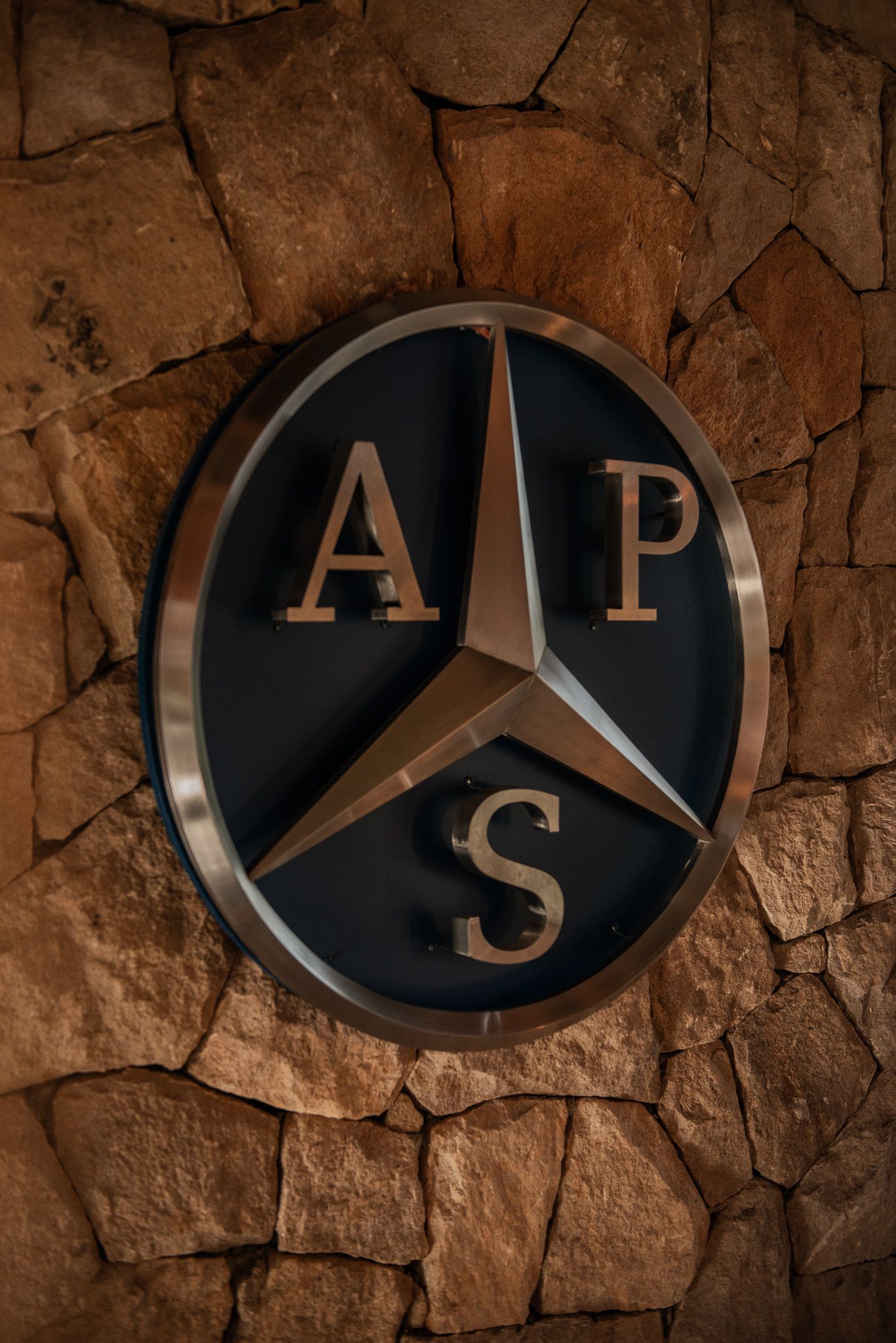 Un logotipo de Mercedes está en una pared de piedra.