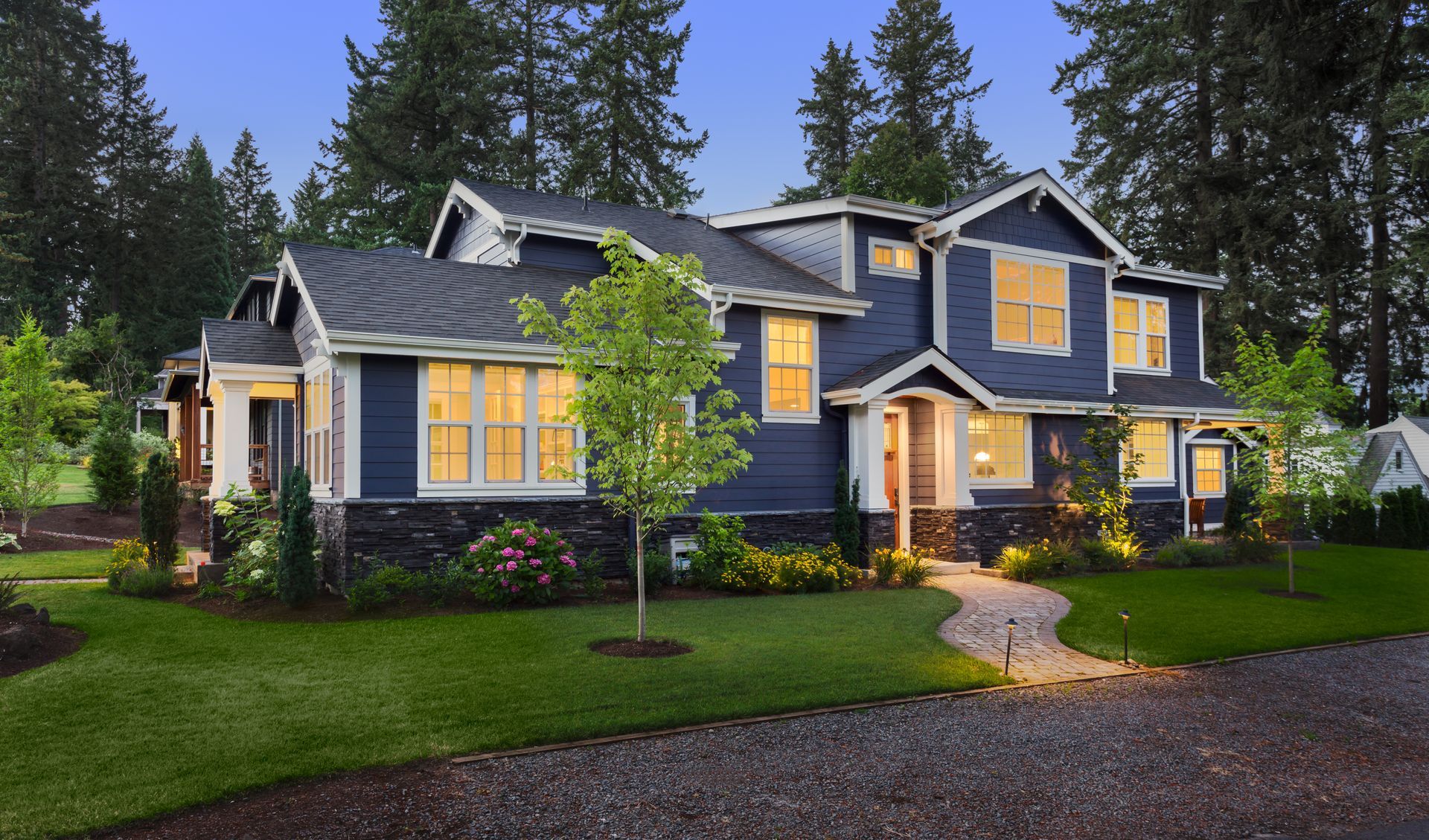 A large house with lots of windows is surrounded by trees