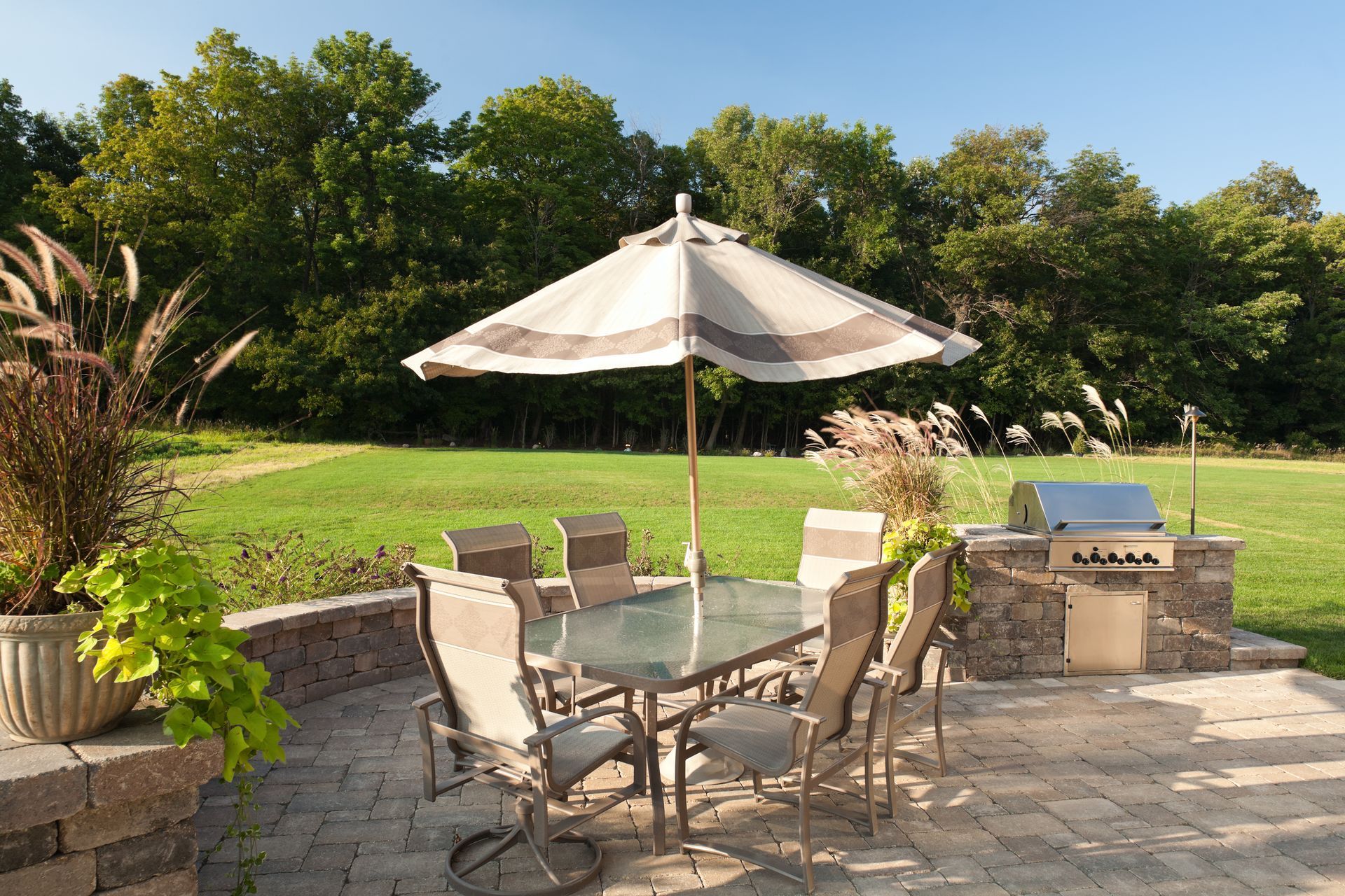 A patio with a table and chairs and an umbrella