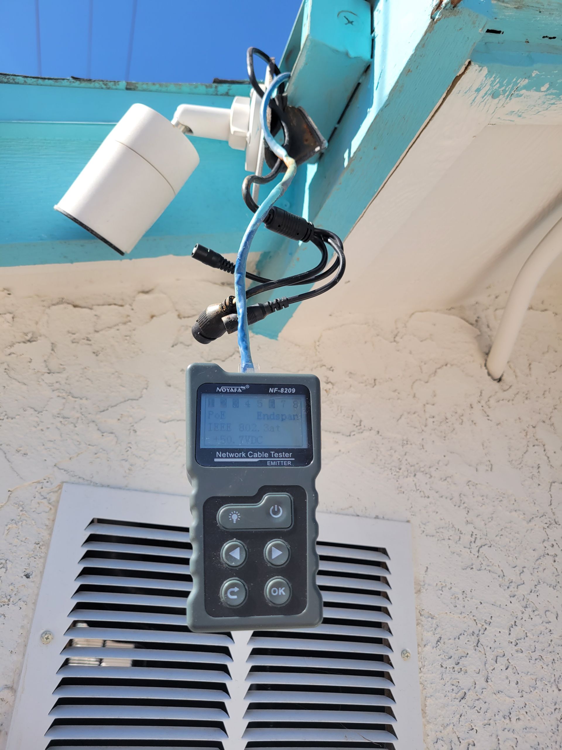 A device hanging from a ceiling with a blue sky in the background