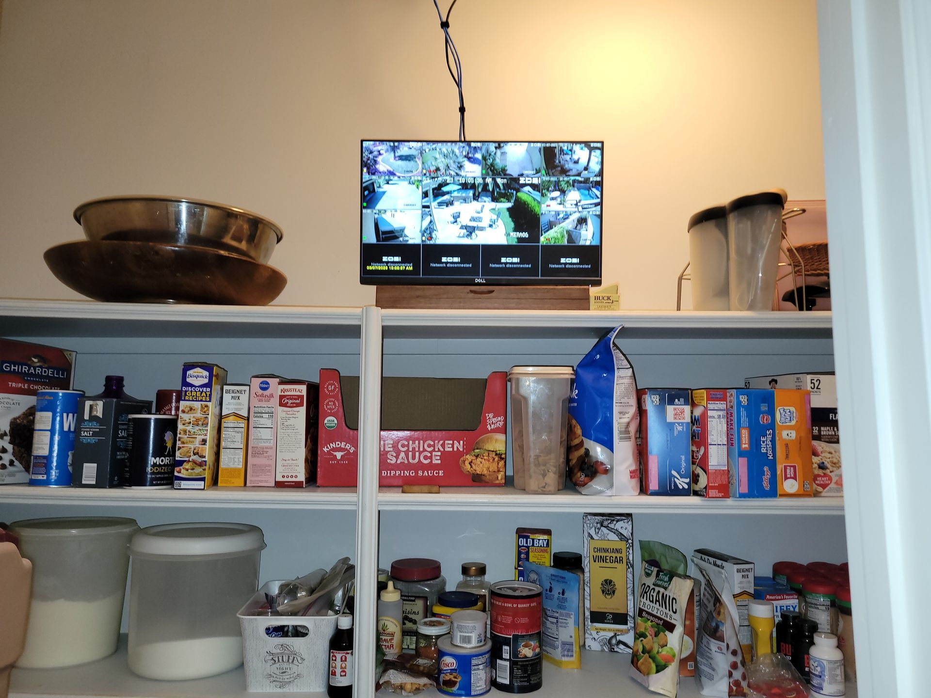 A pantry with a tv hanging from the ceiling