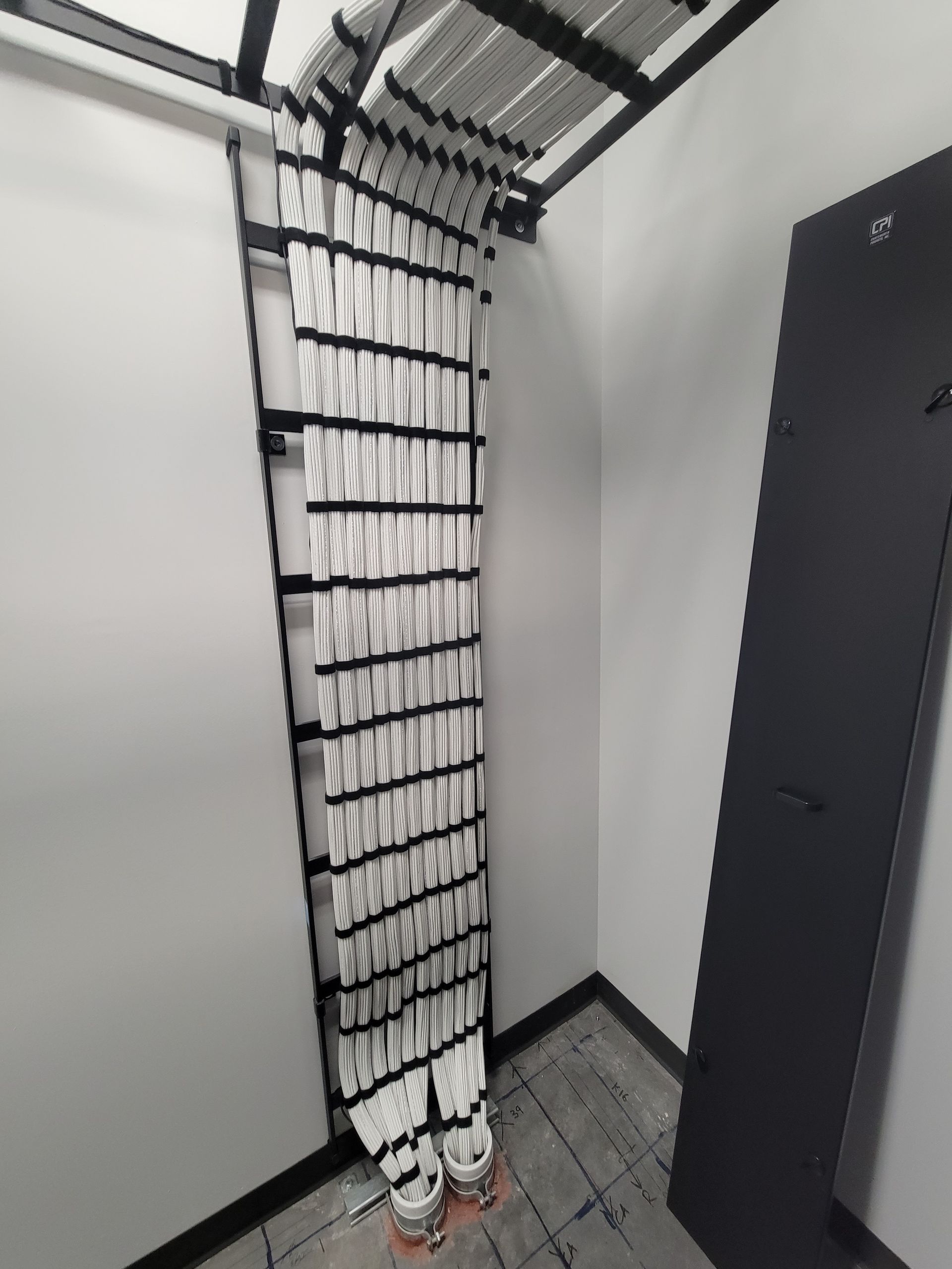 A room with a ladder hanging from the wall and a pair of shoes on the floor.