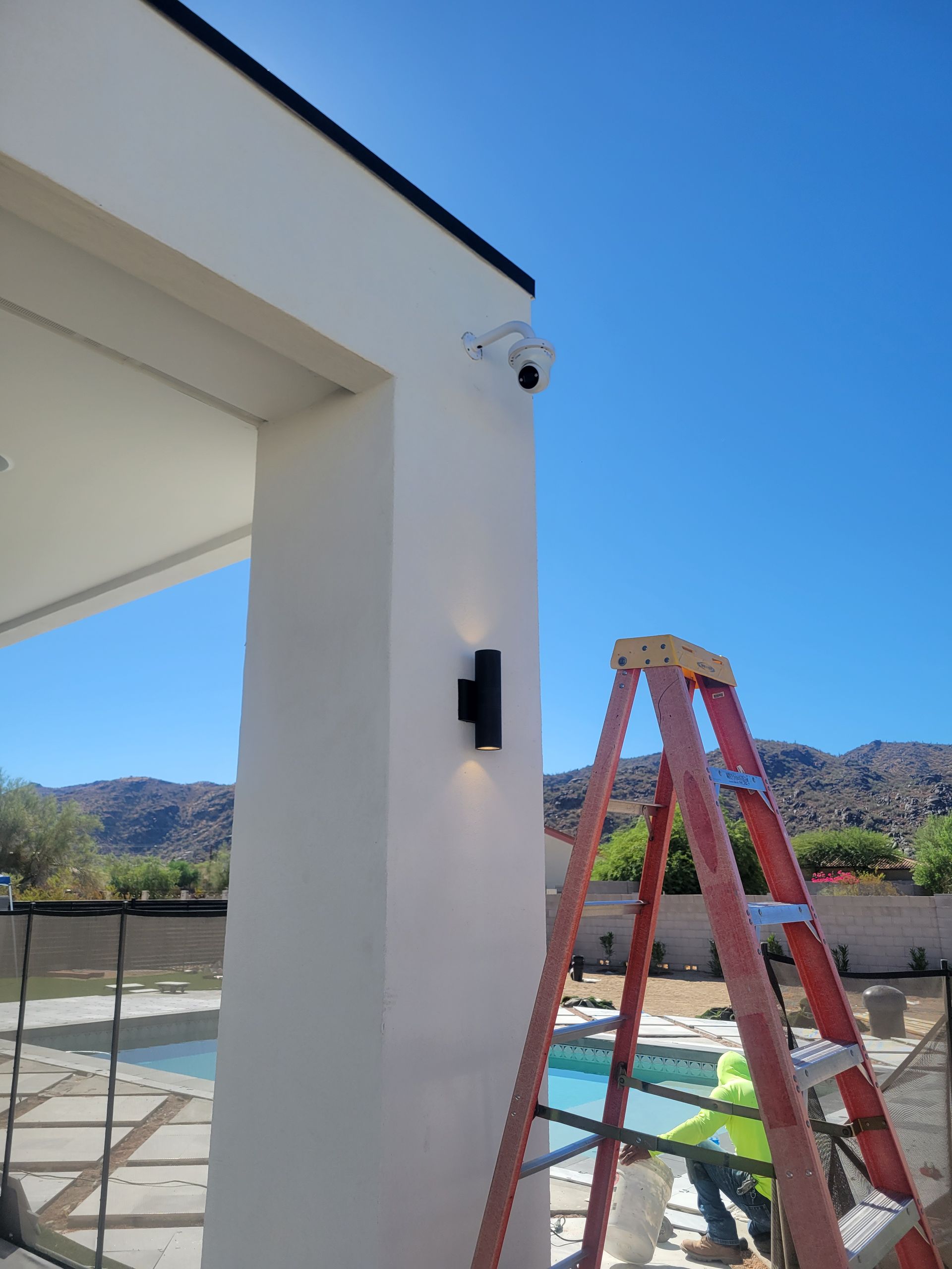 A ladder is leaning against a wall next to a pool