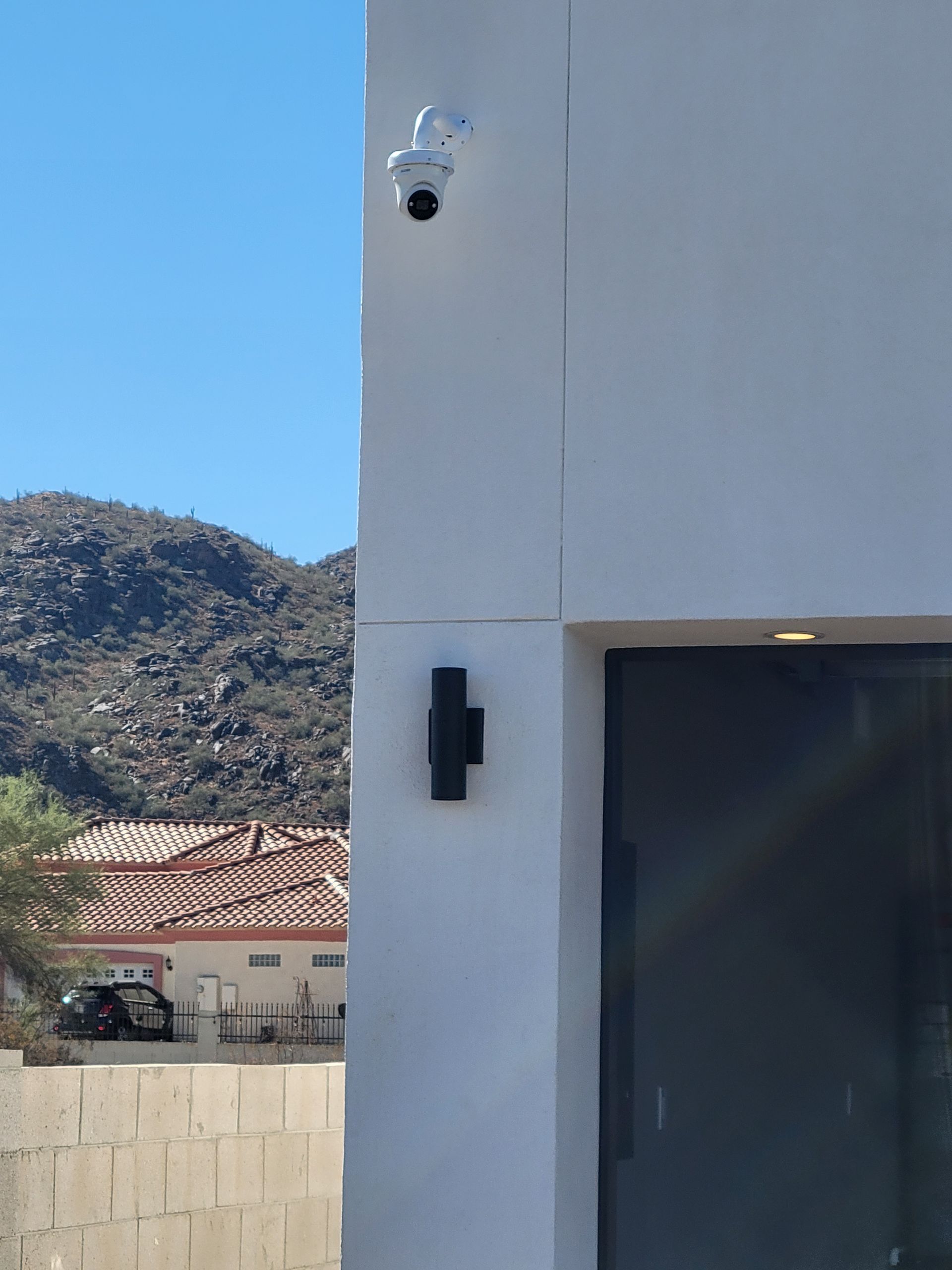 A security camera is mounted on the side of a building.