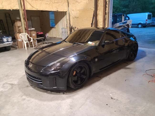 Black Nissan 350Z sports car in a garage.