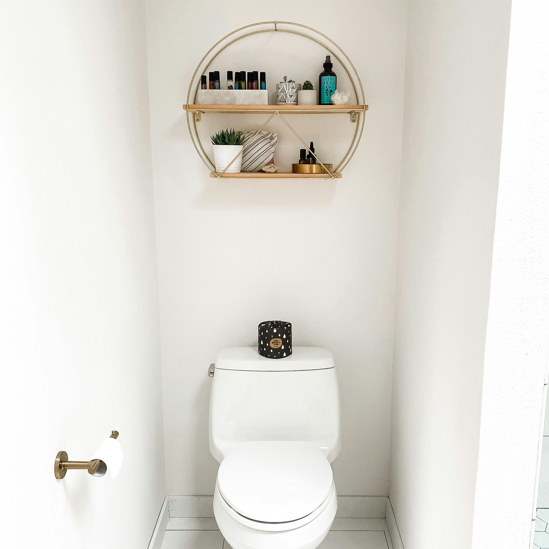 A bathroom with a toilet and a shelf above it.