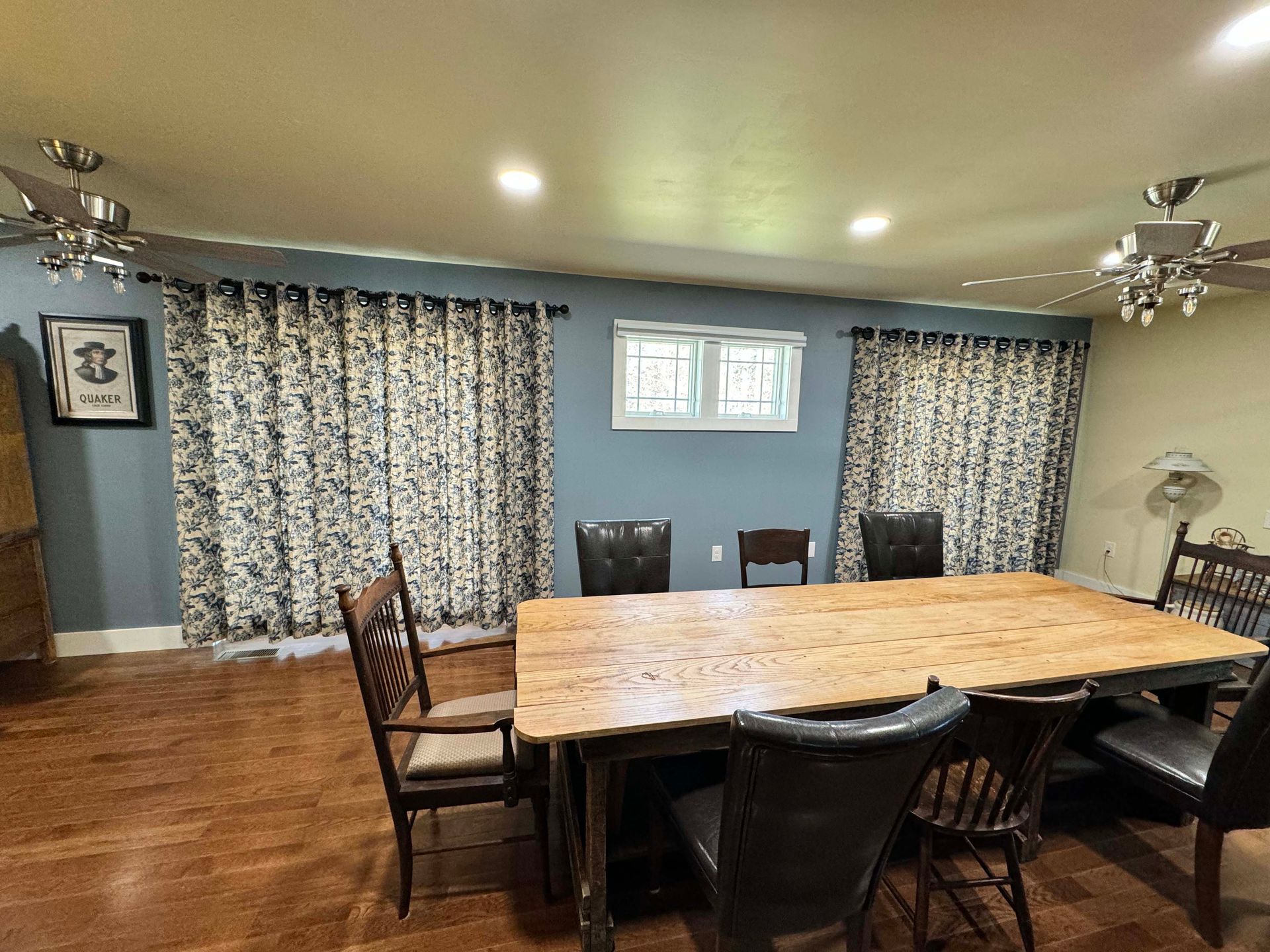 A dining room with a table and chairs and a ceiling fan.