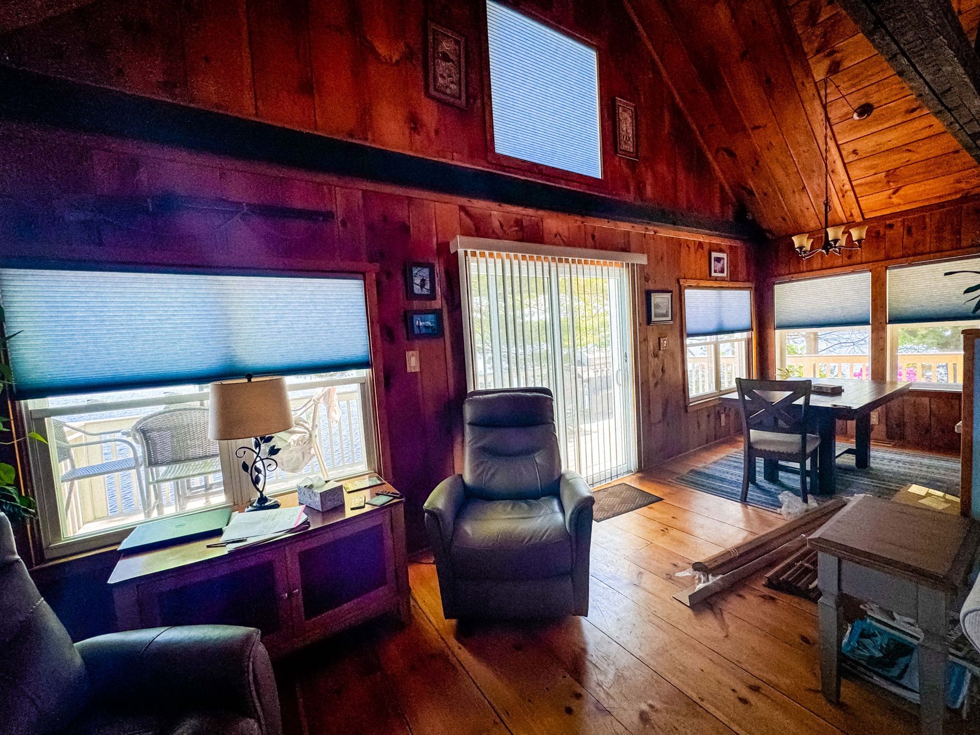 A living room with two chairs , a table , and a sliding glass door.