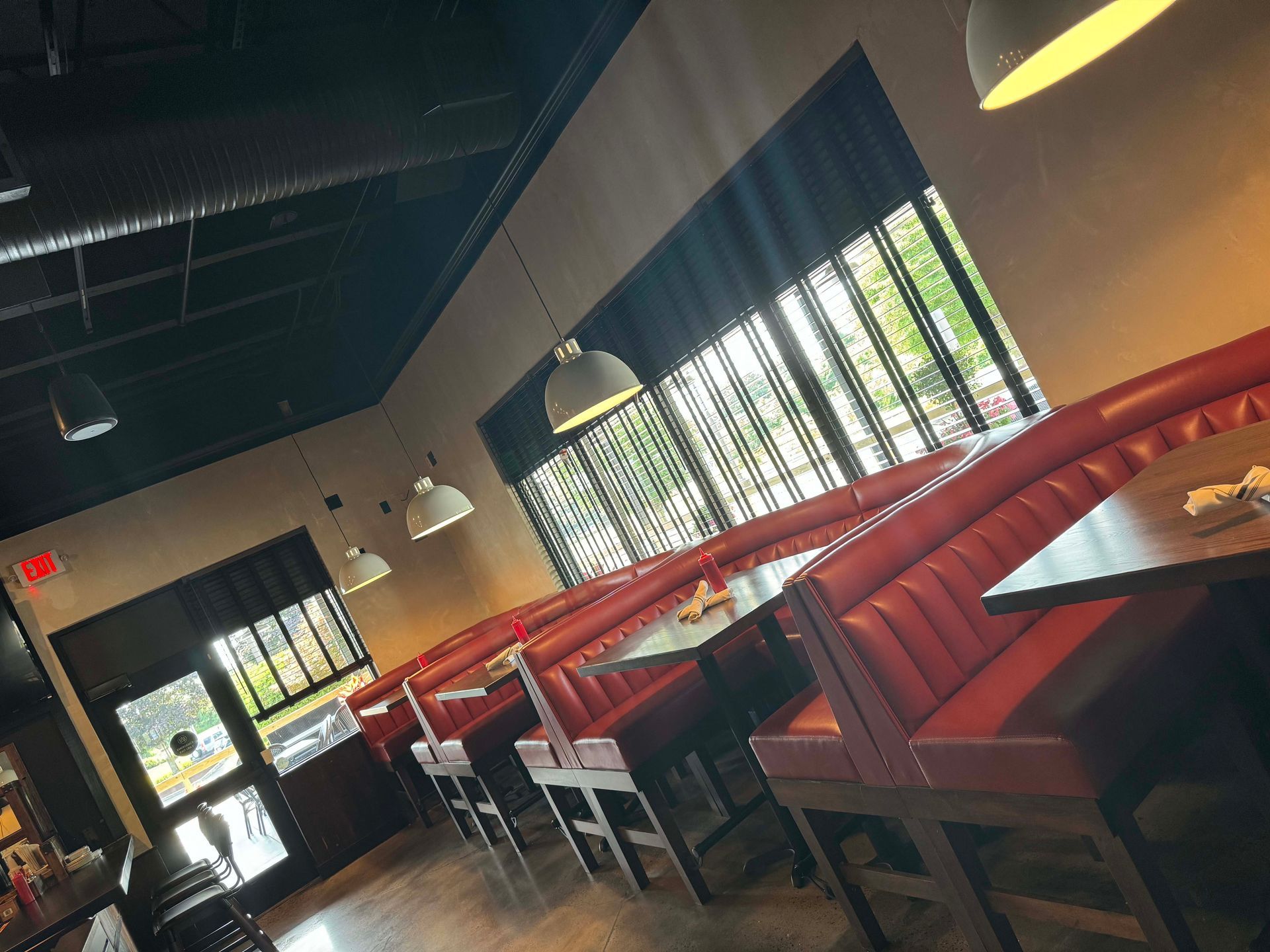 A restaurant with a lot of red booths and tables