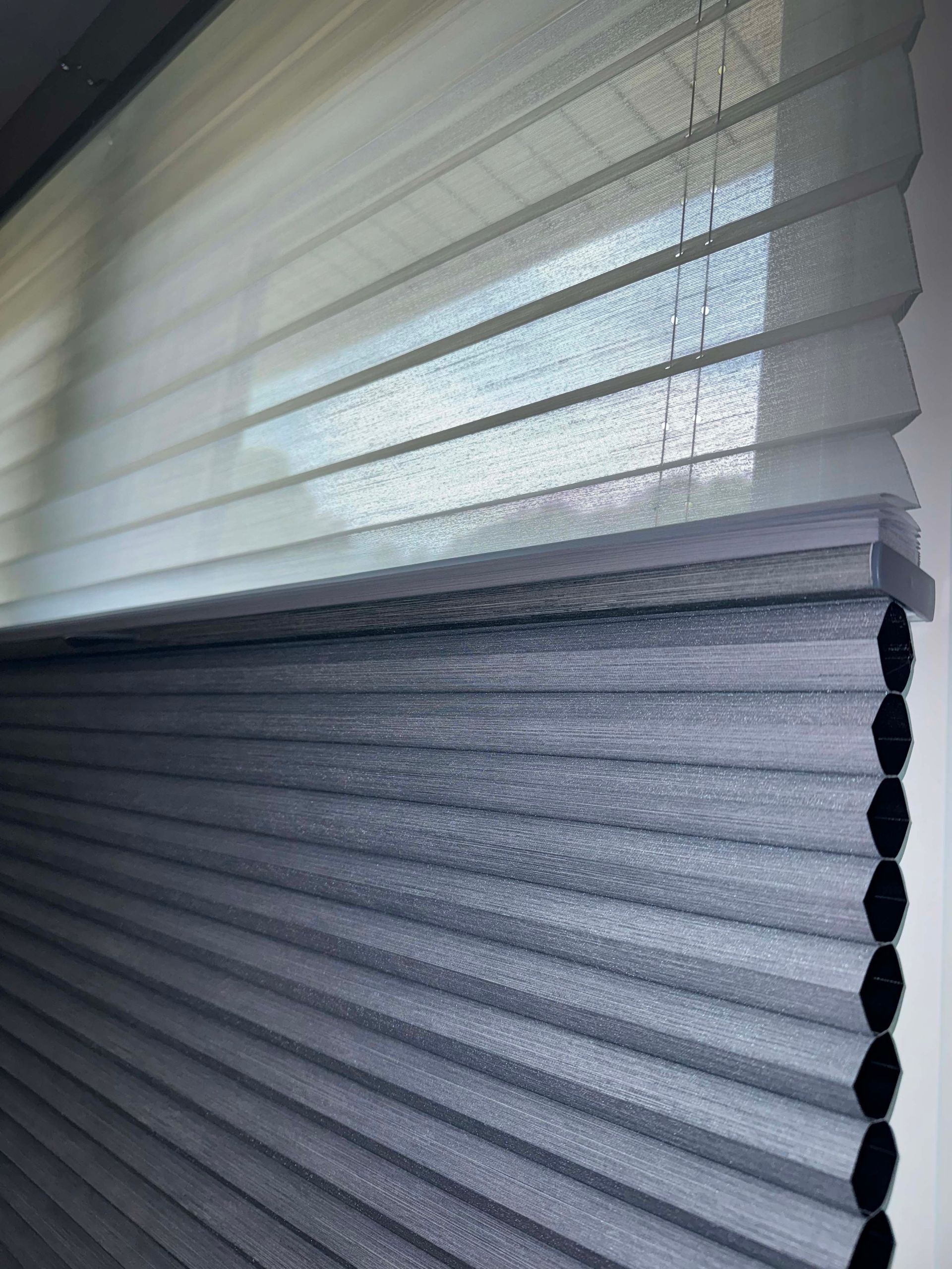 A close up of a honeycomb blind on a window.