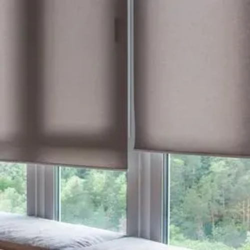 A pair of roller blinds on a window in a living room.