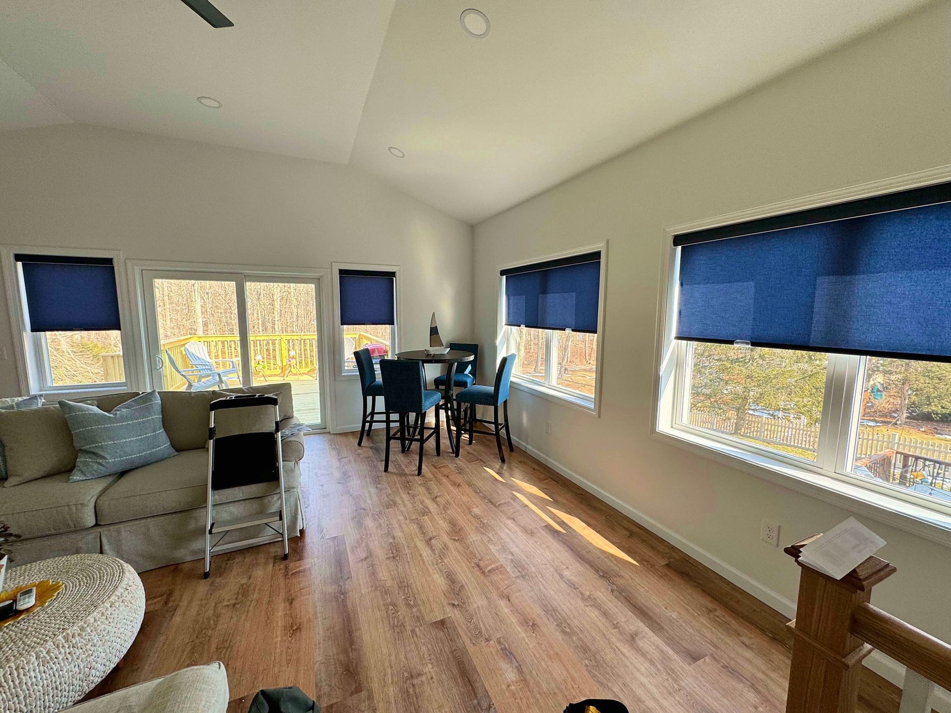A living room with a couch , table , chairs and blue blinds.