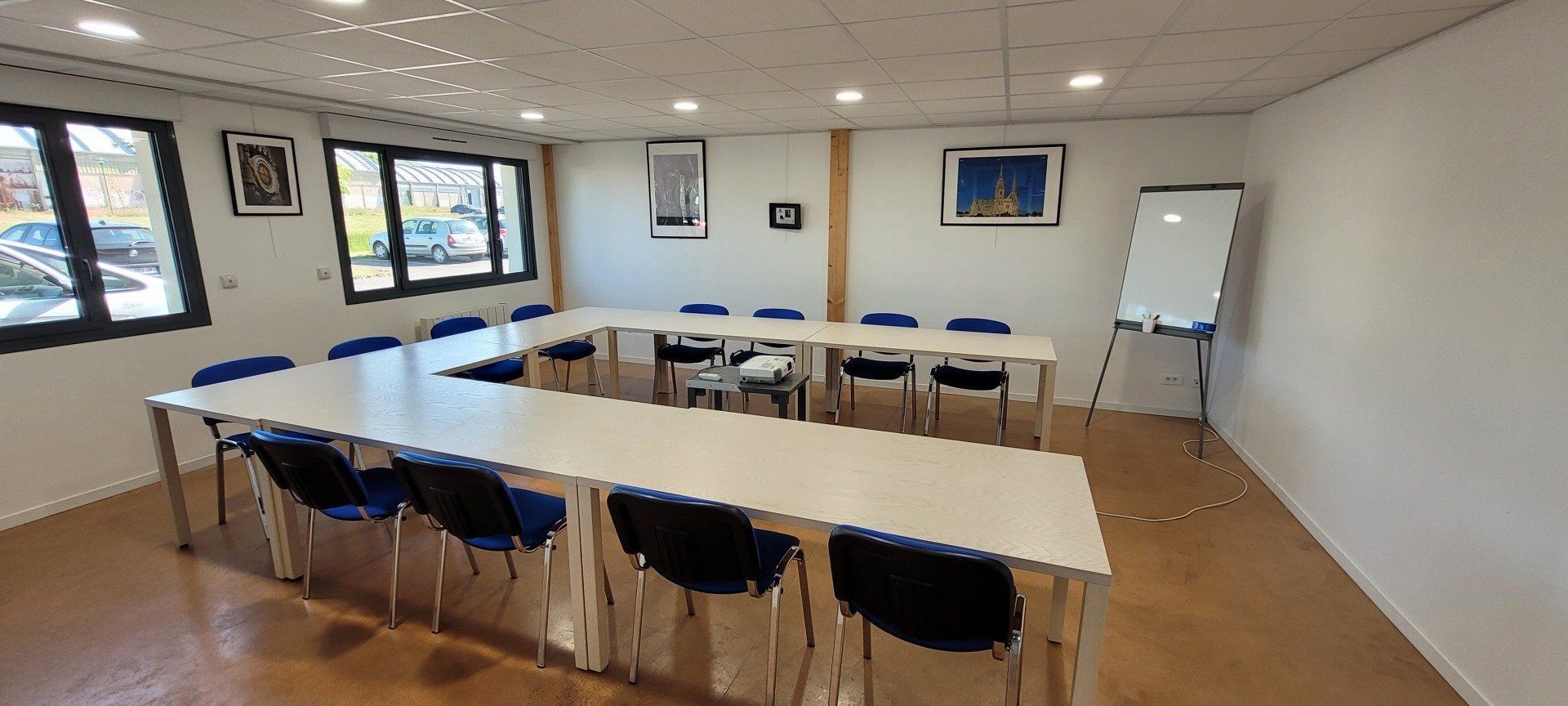 Une salle de conférence avec une longue table et des chaises et une télévision à écran plat.