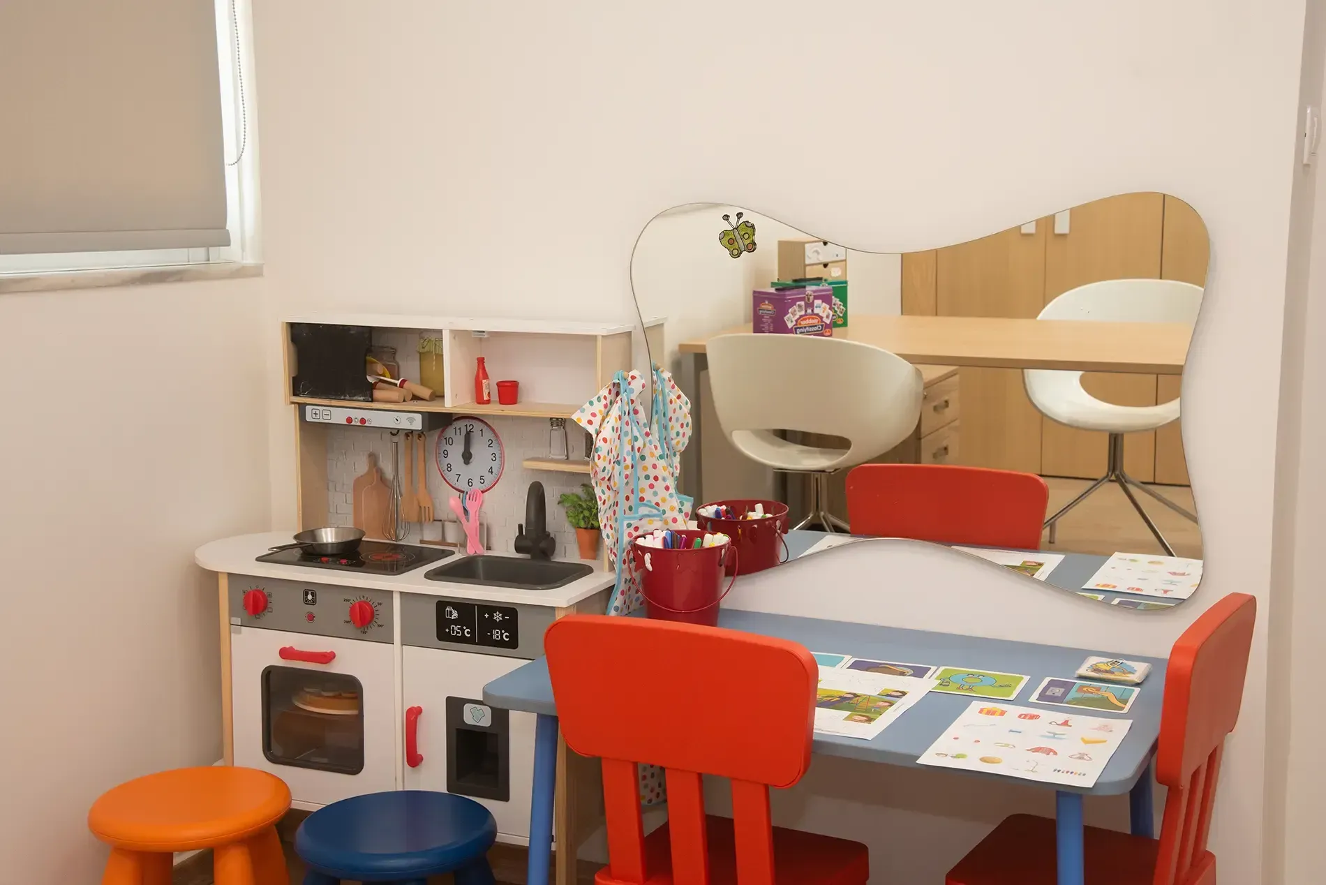 Ένα δωμάτιο με τραπέζι και καρέκλες και κουζίνα παιχνιδιών.