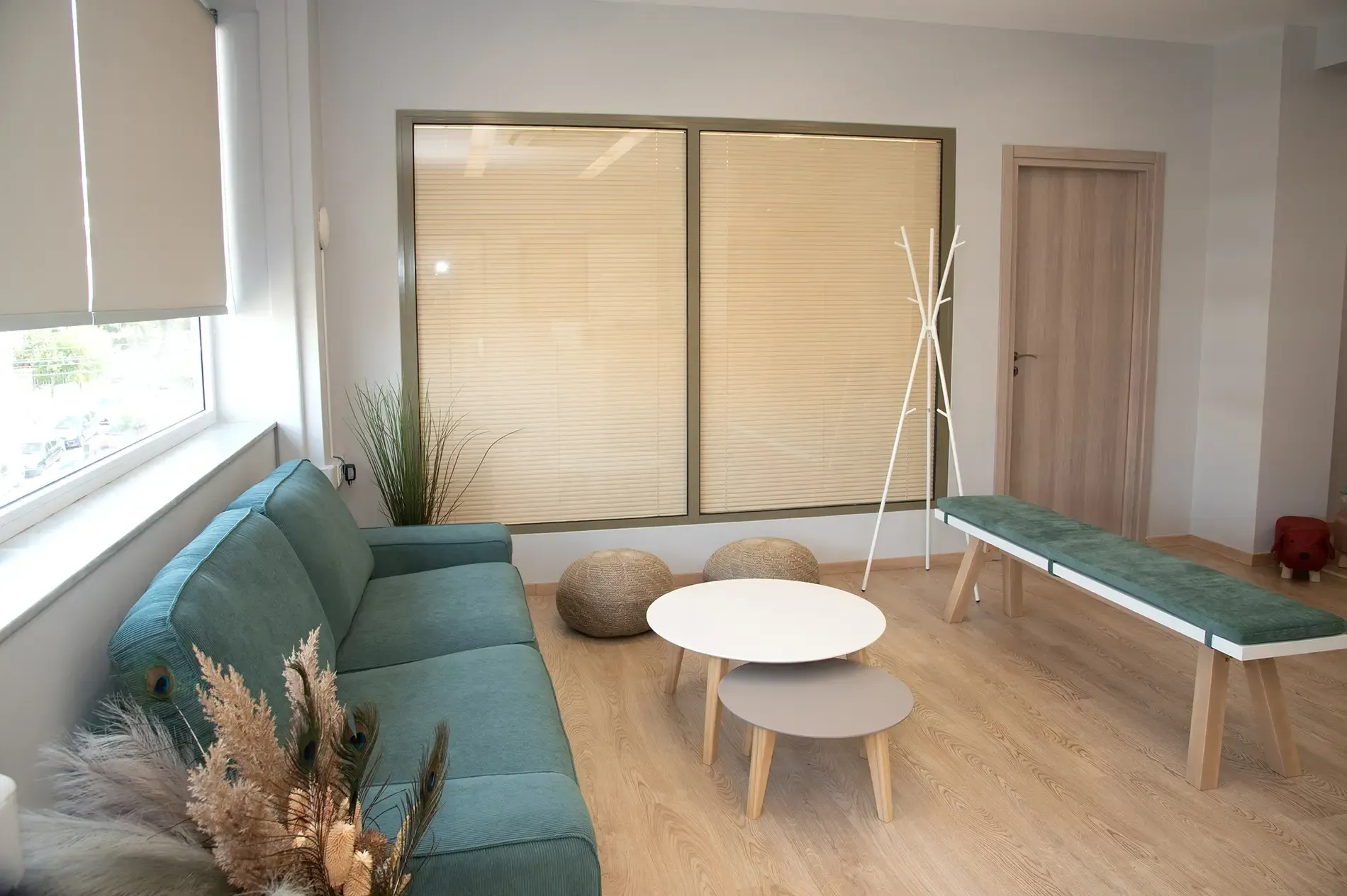 Ένα σαλόνι με καναπέ, τραπέζι, πάγκο και παράθυρο.