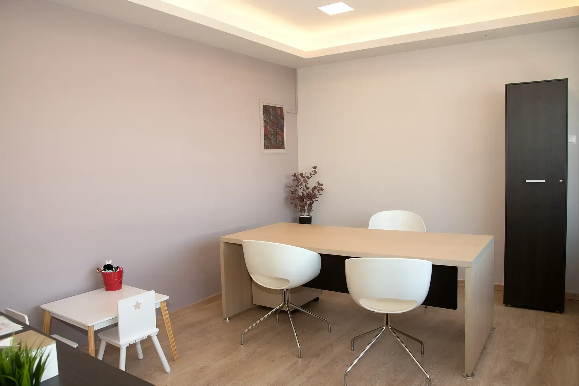 Ένα δωμάτιο με γραφείο, καρέκλες και τραπεζάκι.