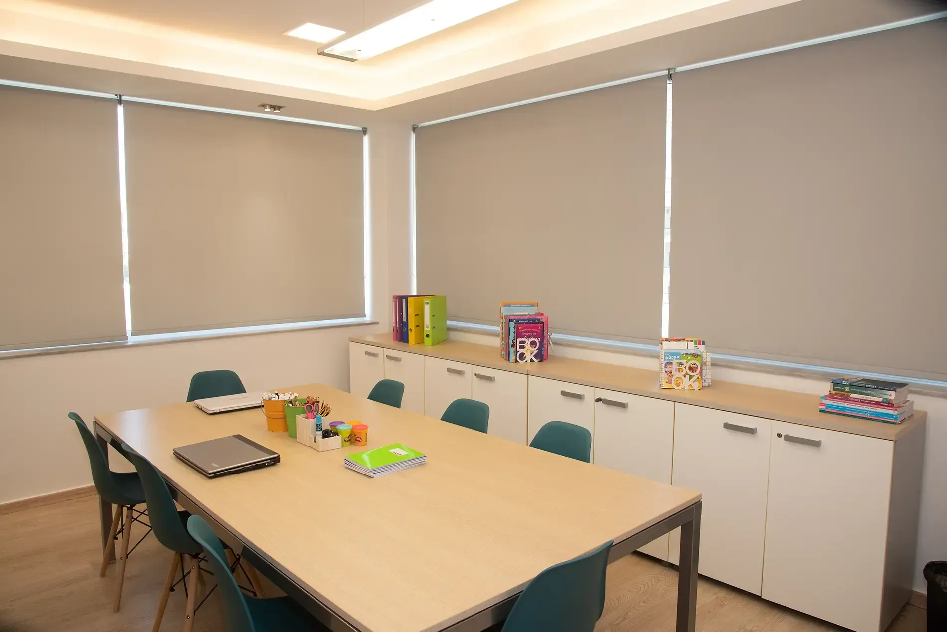 Μια αίθουσα συνεδριάσεων με ένα μακρύ τραπέζι και καρέκλες.