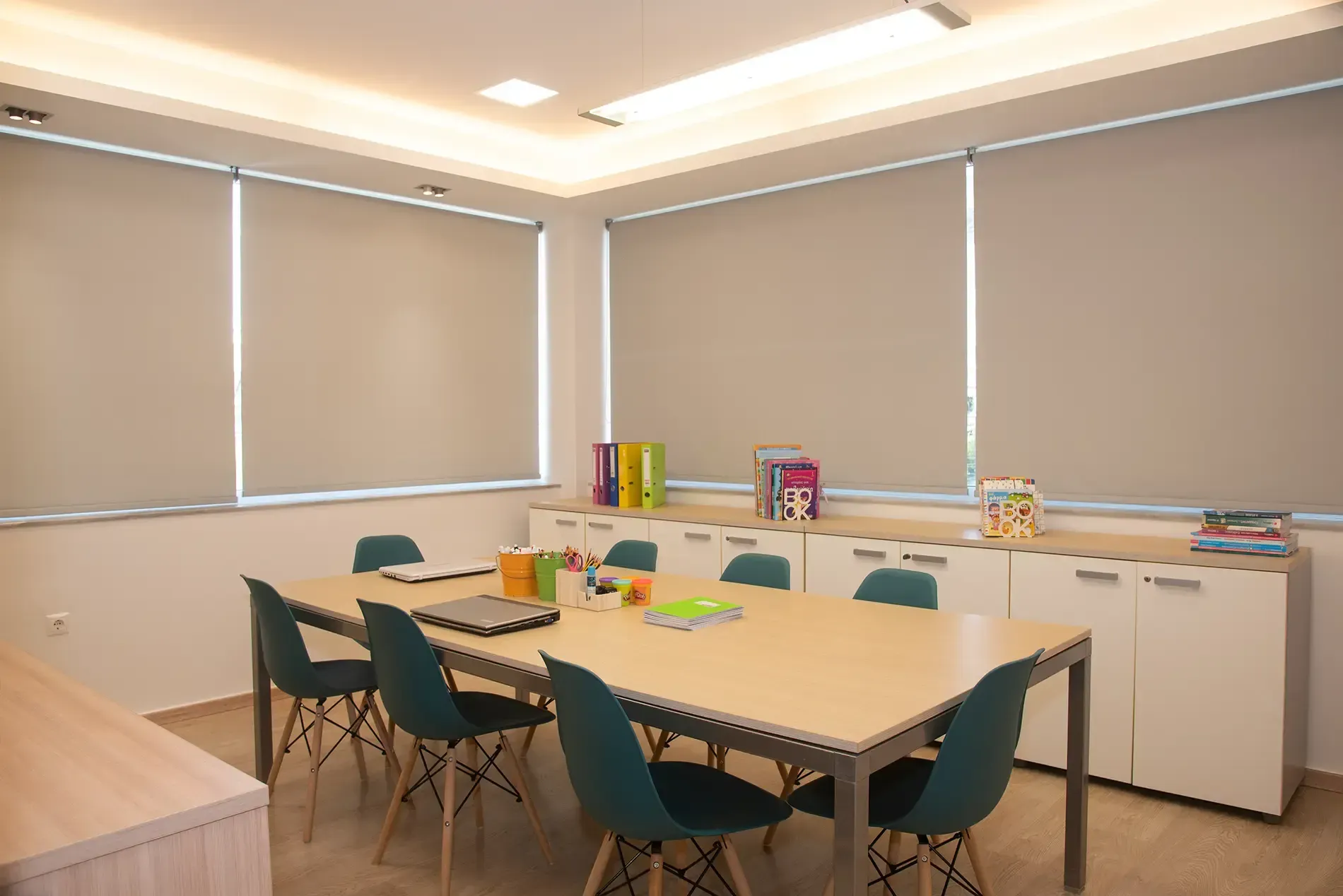 Μια αίθουσα συνεδριάσεων με ένα μακρύ τραπέζι και καρέκλες.