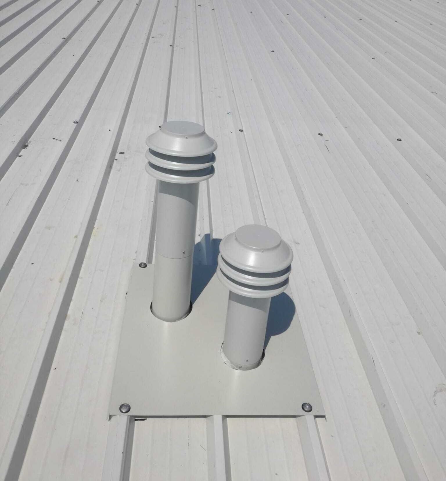 Un tetto bianco con due tubi bianchi sopra